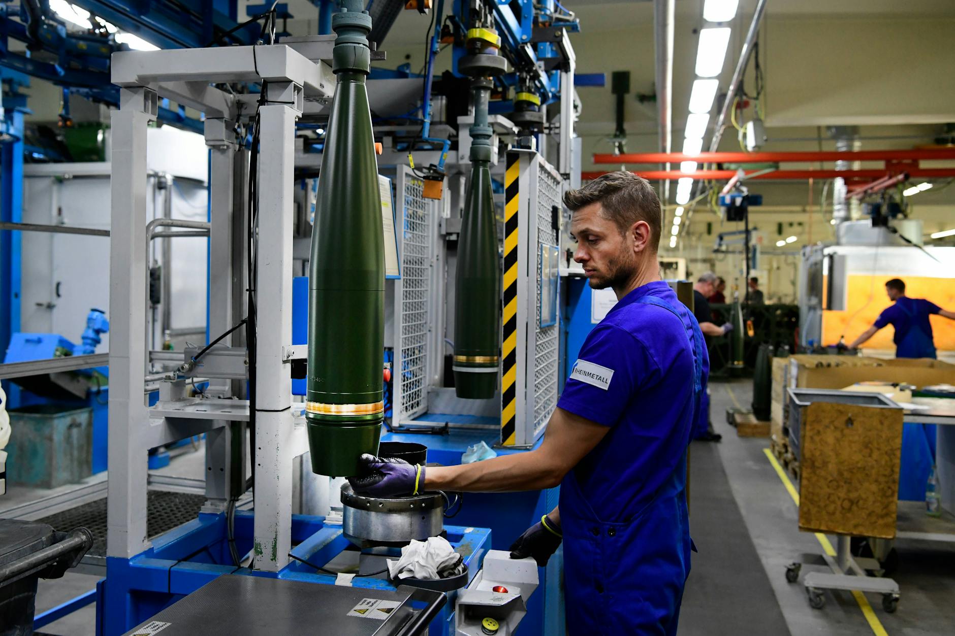 Ein Arbeiter lackiert 155-Millimeter-Geschosse im Rheinmetall-Werk in Unterlüß.