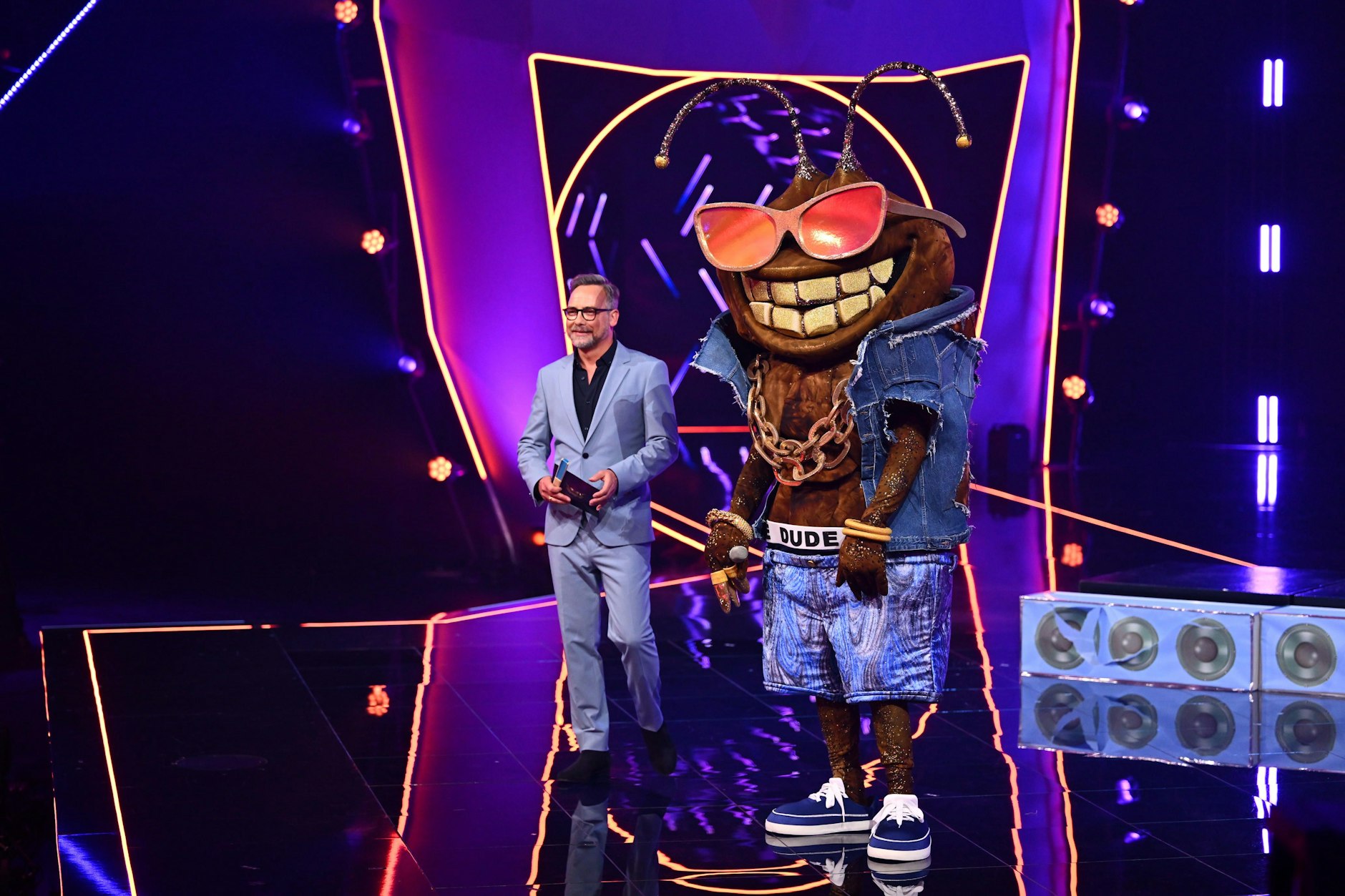 Die Stinkwanze Dude mit Moderator Matthias Opdenhövel auf der Bühne von „Masked Singer“.