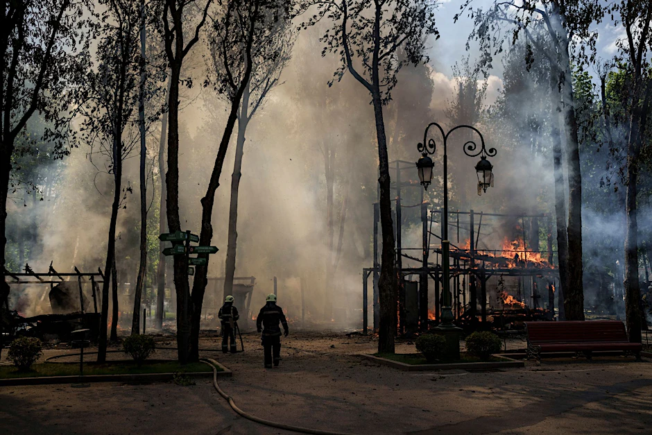 Nach einem russischen Angriff löschen Feuerwehrleute in Charkiw einen Brand in einem Park.