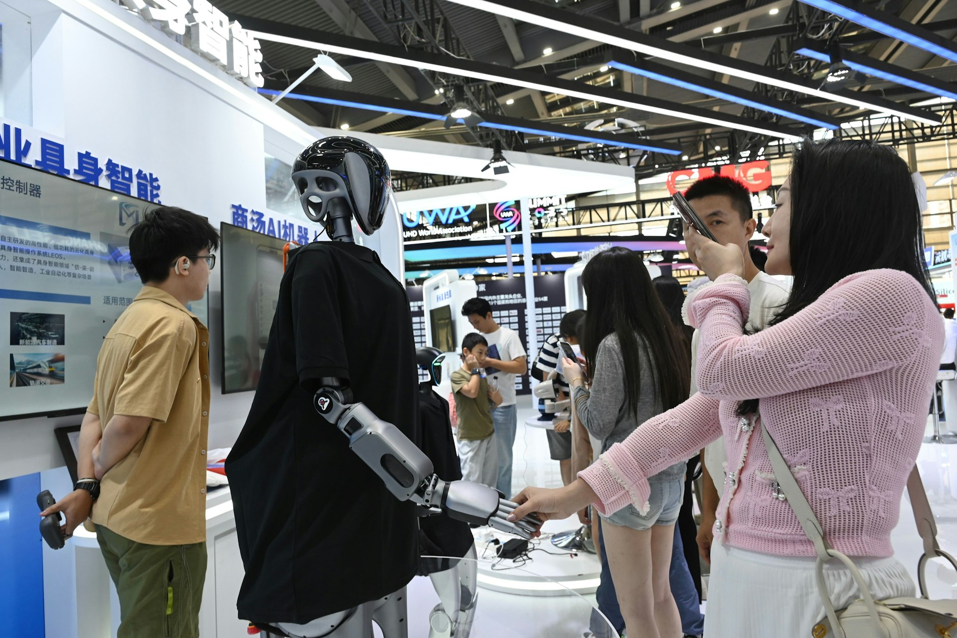 Begegnung der chinesischen Art: Besucherin (r.) und Roboter auf dem Consumer Electronics Innovation Congress in Shenzhen