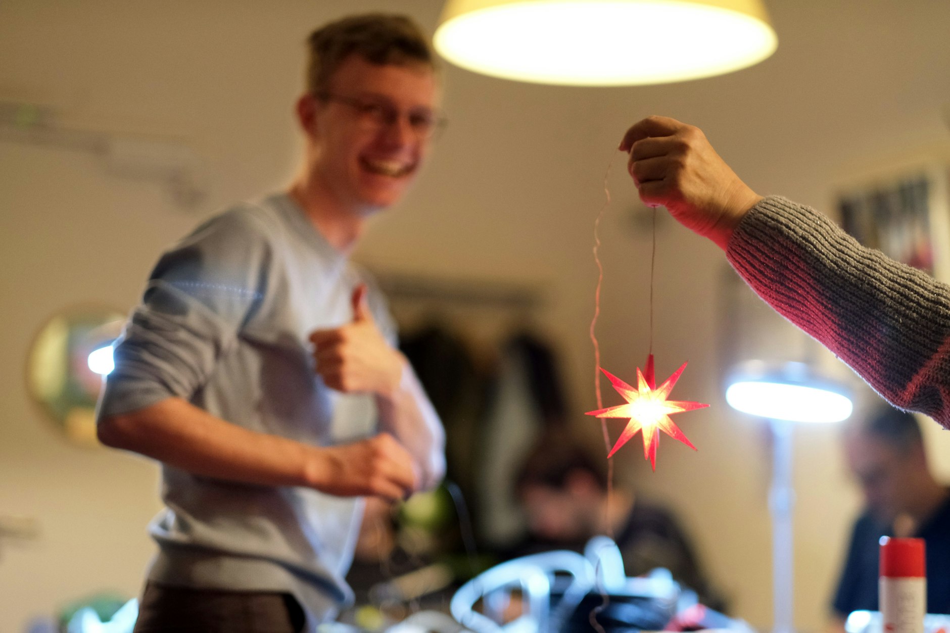 Industriedesigner Moritz Tscherner, der jüngste der ehrenamtlichen Tüftler, hat den Herrnhuter Stern repariert, den Besitzerin Gaby in die Höhe hält.