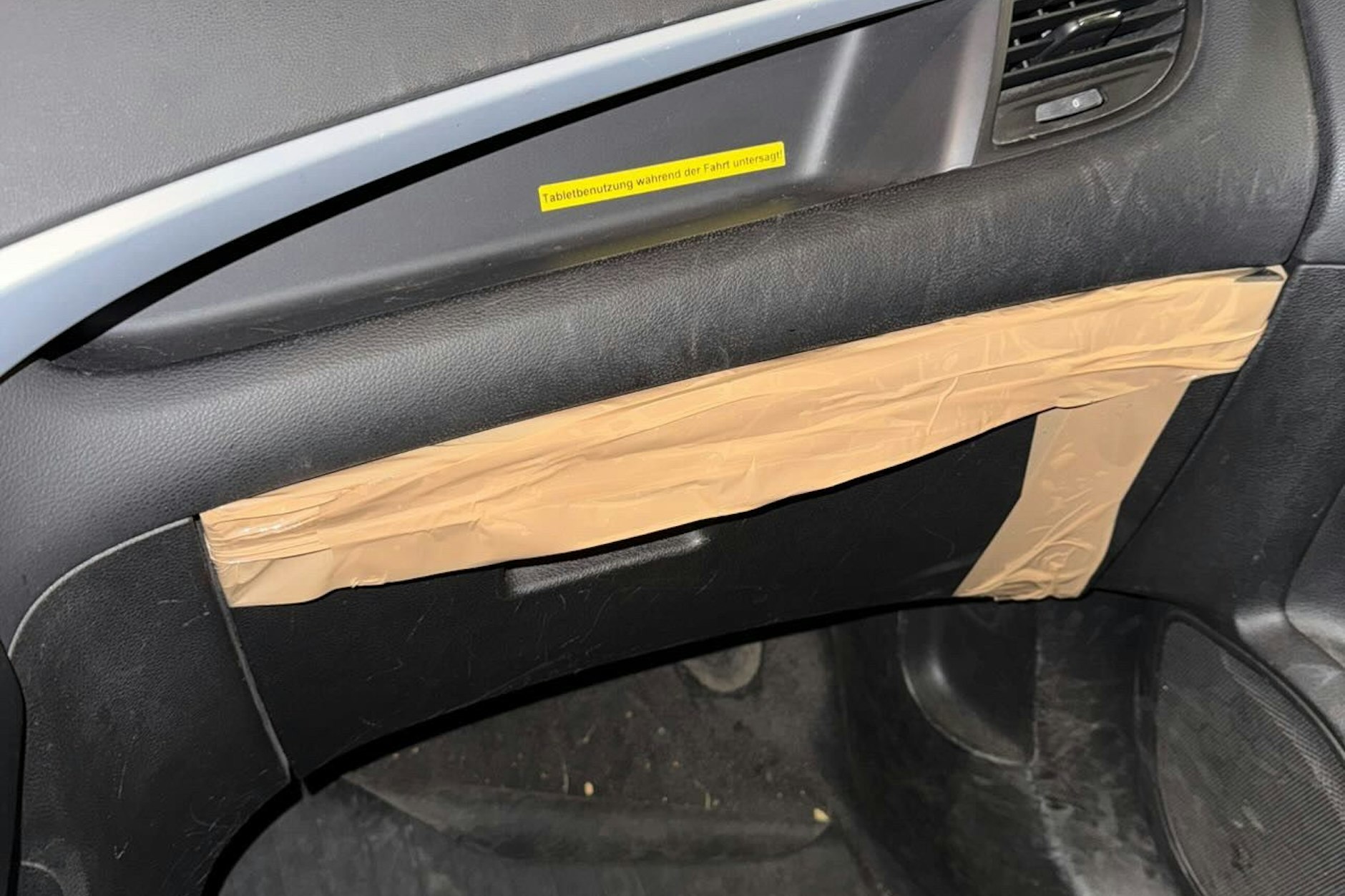 Das kaputte Handschuhfach eines Dienstwagens der Berliner Polizei kann nur noch mit Klebeband zusammengehalten werden.