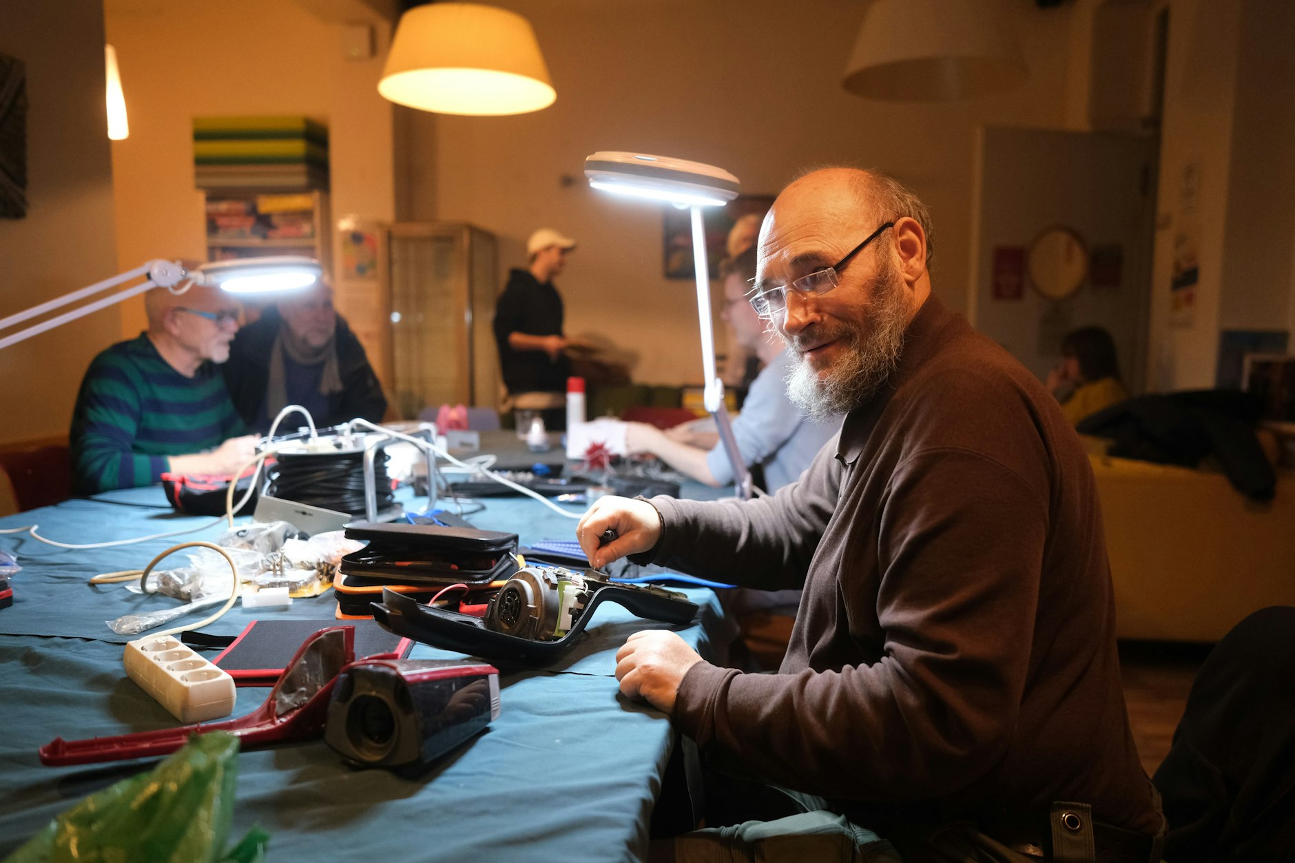 Das Nachbarschaftscafé im Stadtteilzentrum Pankow wird jeden ersten Montag im Monat zur Werkstatt. Elektriker und Ehrenamtlicher Bernd Wagner (vorn) ist an einem kaputten Handstaubsauber zugange.