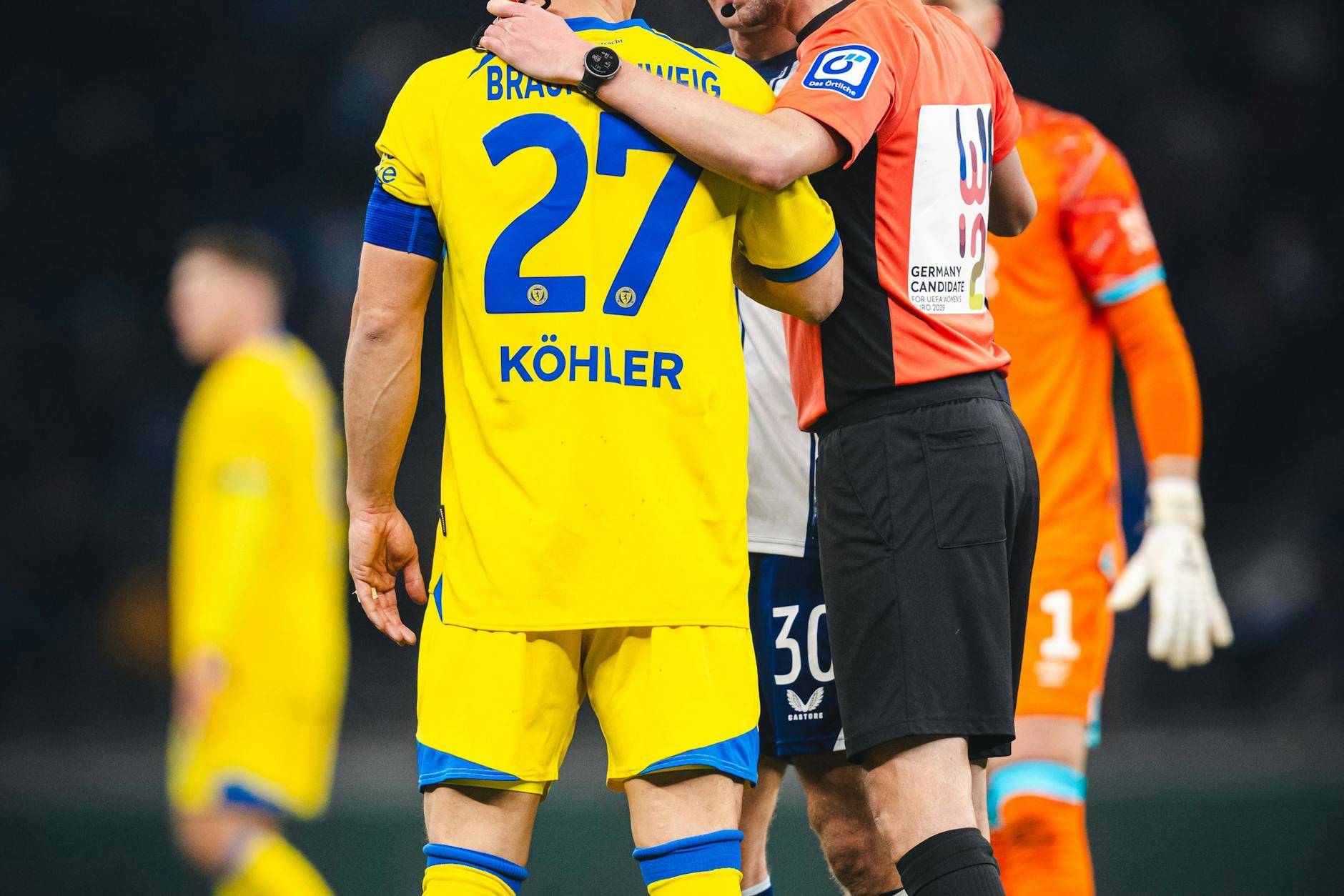 Augen auf bei der Farbwahl! Schiedsrichter Michael Bacher und Braunschweigs Torwart Ron-Thorben Hoffmann im orangen Trikot.