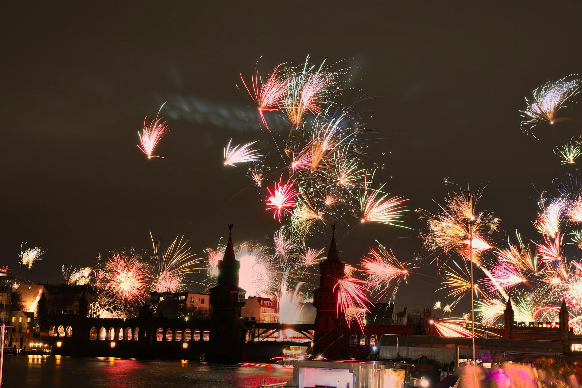 Feuerwerkskörper gehen an Silvester hinter der Oberbaumbrücke in den Nachthimmel hoch.