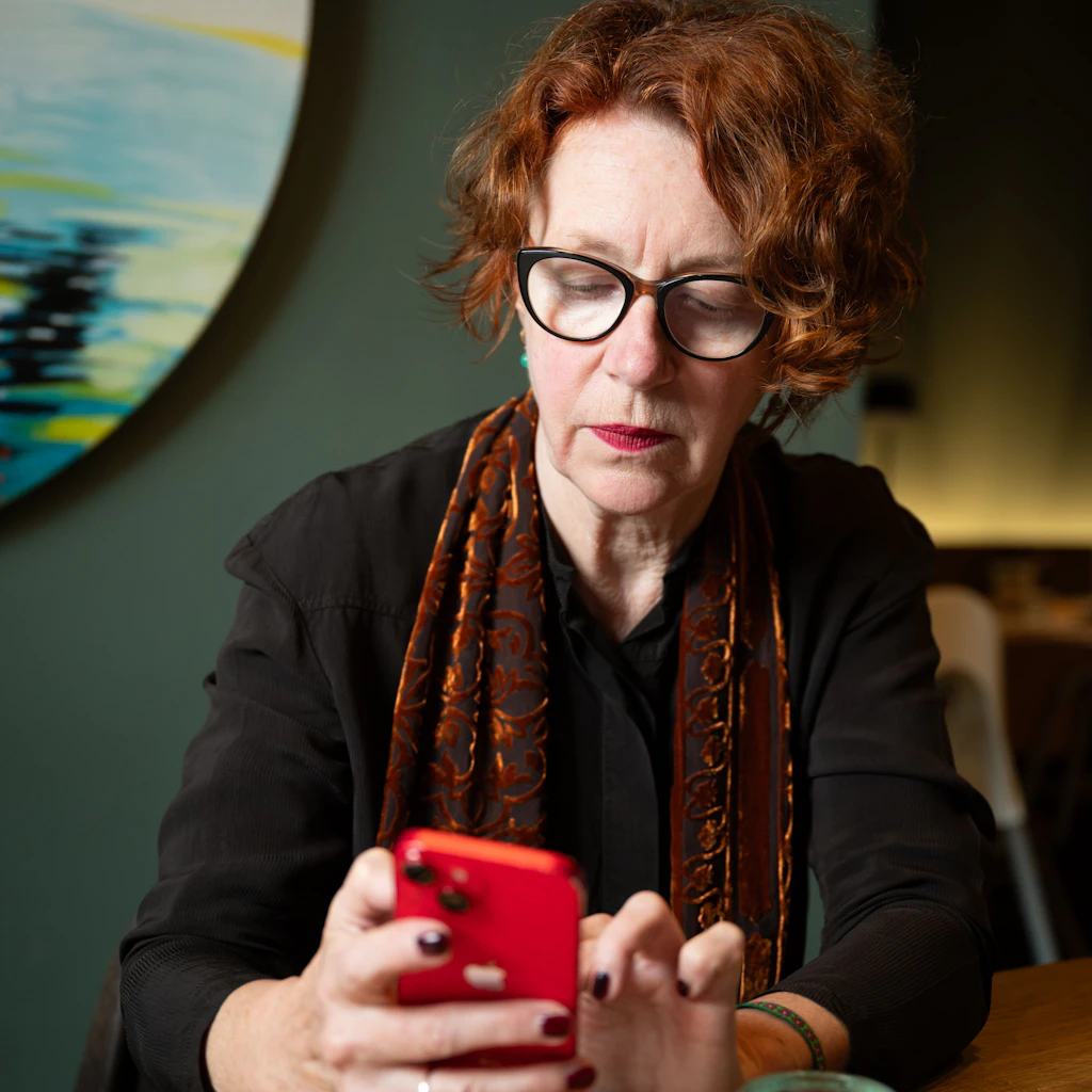 Ulrike Guérot liest auf ihrem Handy das Urteil des Landesarbeitsgerichts (LAG) Köln.