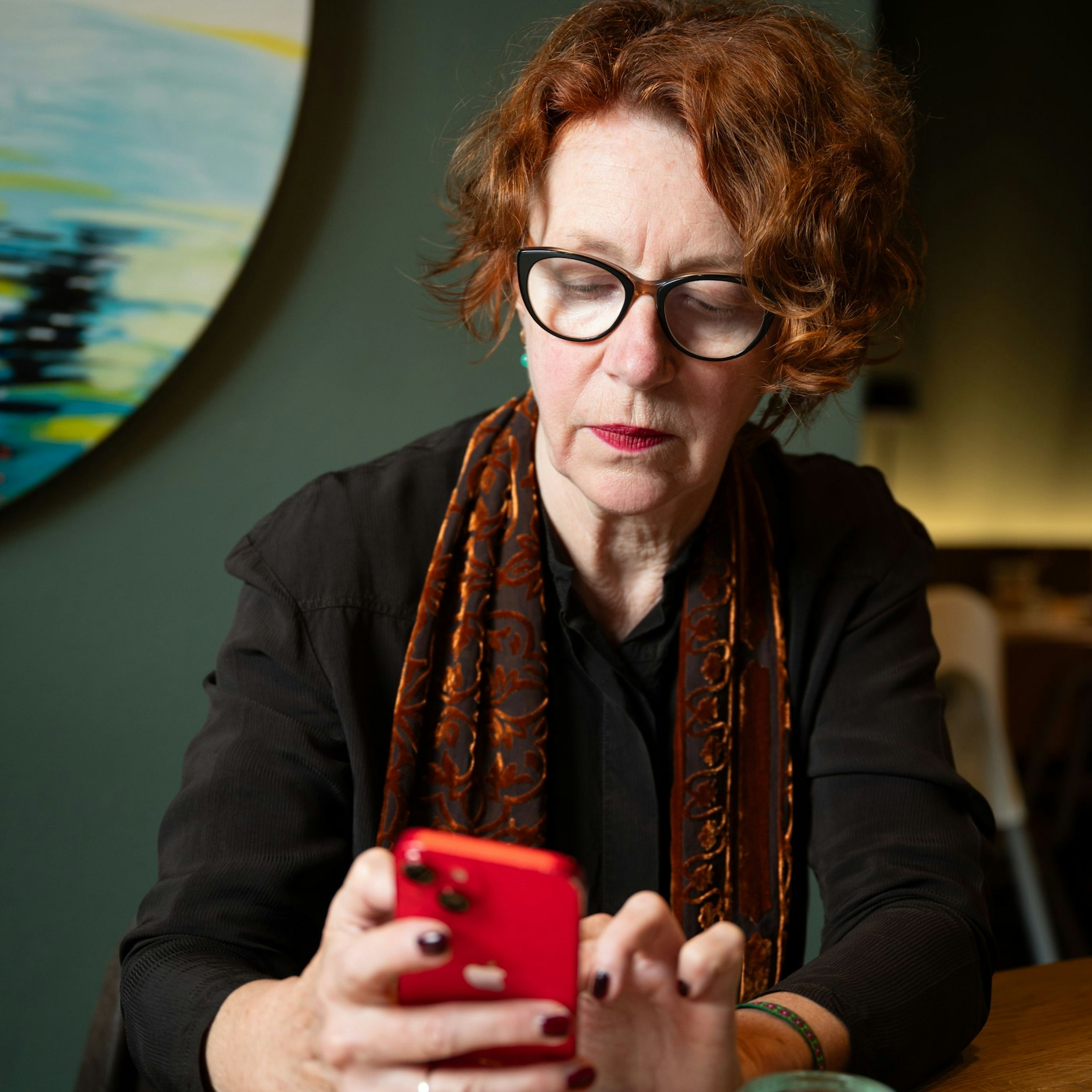 Ulrike Guérot liest auf ihrem Handy das Urteil des Landesarbeitsgerichts (LAG) Köln.