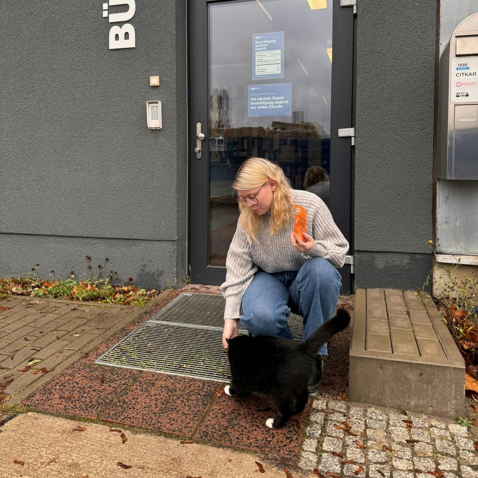 Katze Miffy wird von der wissenschaftlichen Volontärin Virginia Eichstädt vor dem DDR-Depot in Berlin-Marzahn mit Leckerlis verwöhnt.