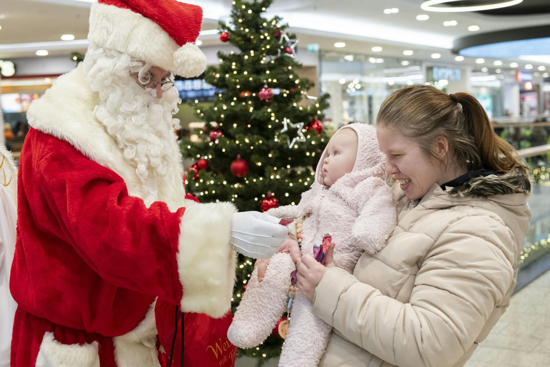 Ivie Anushka Jane macht große Augen, als der Weihnachtsmann sie und Mama Janet begrüßt.