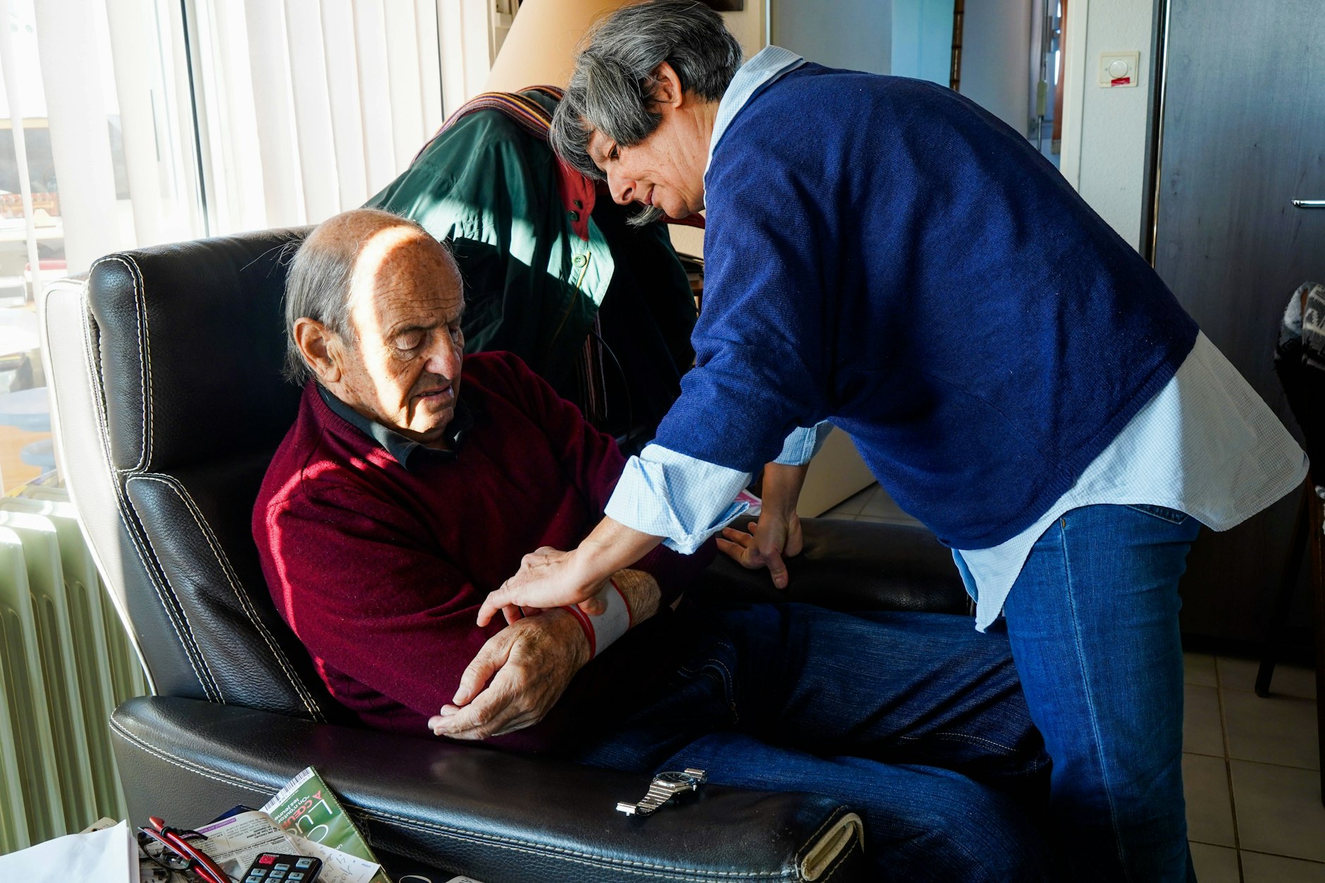Ein pflegebedürftiger Mann wird von einer Angehörigen versorgt.