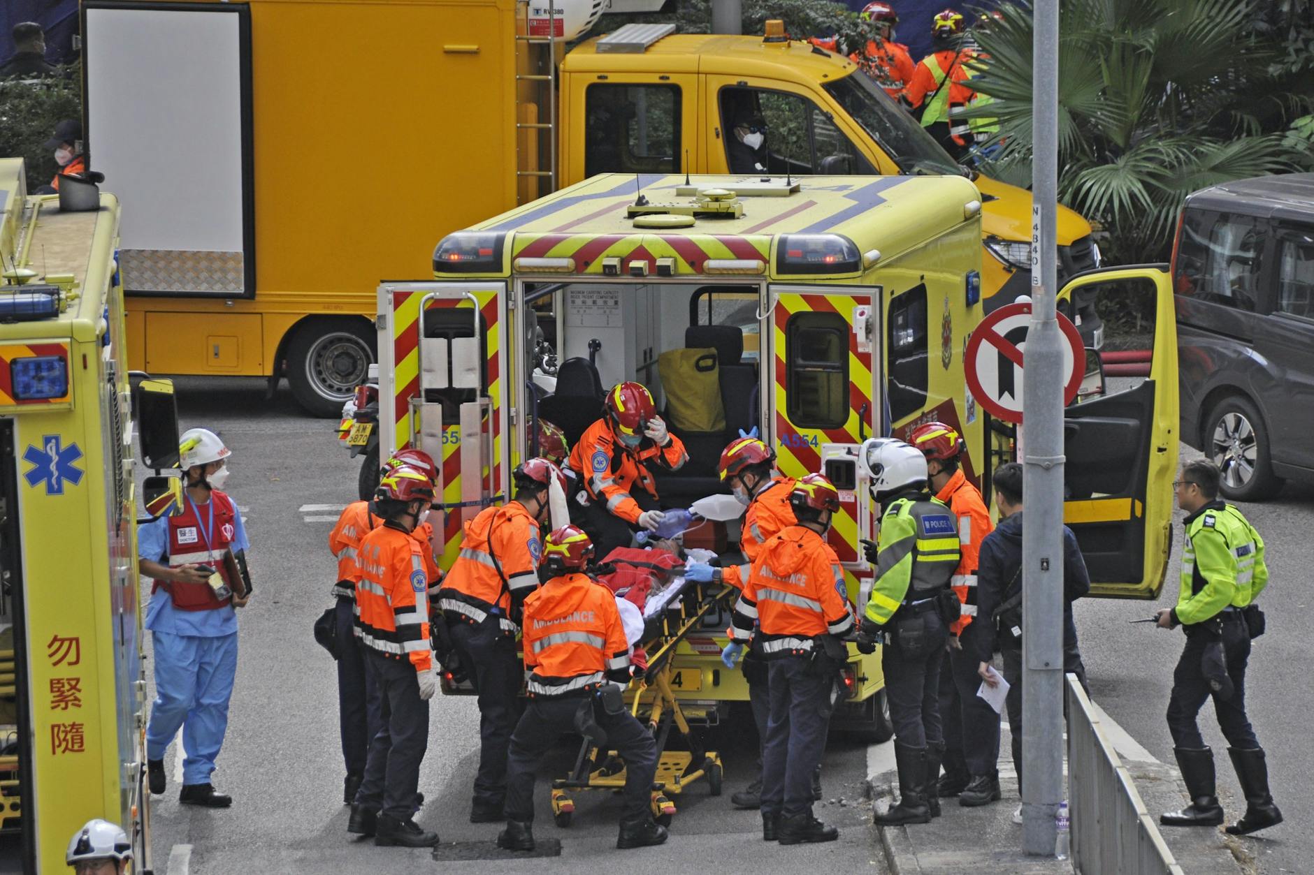 Feuerwehrleute bringen am Donnerstagmorgen eine gerade gerettete, verletzte Person u einem Krankenwagen. Foto: Uncredited/kyodo/dpa