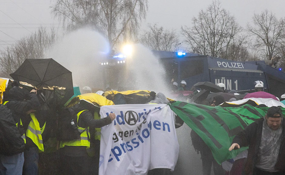 Die Polizei setzt Wasserwerfer gegen Demonstranten ein, die die B429 nahe der Lahnbrücke blockieren.