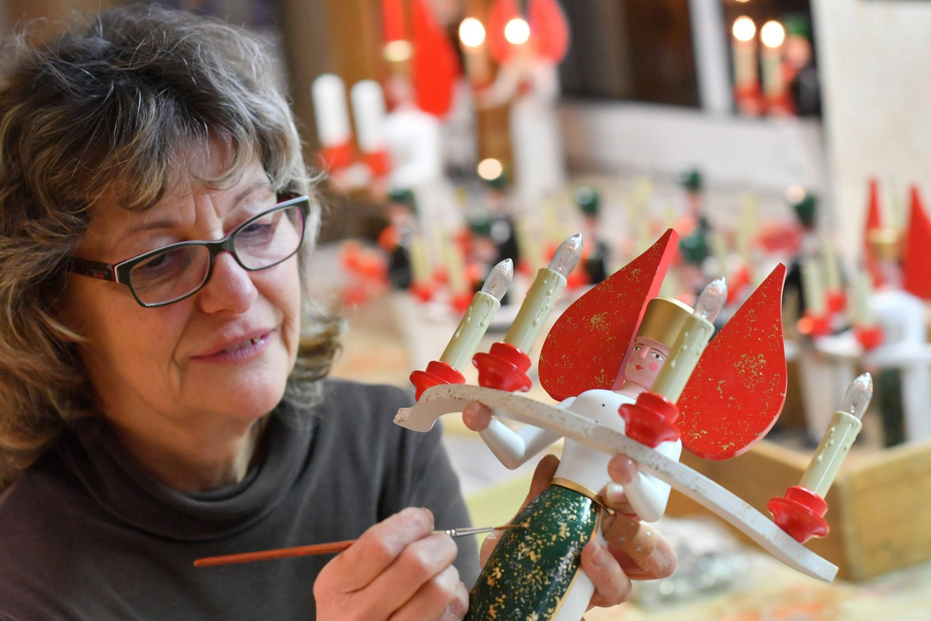 Spielzeugmacherin Romy Koehler bemalt einen Lichterengel in einer Werkstatt in Seiffen – Jahresendflügelfiguren werden hier noch heute hergestellt. Aber: Nannte man sie in der DDR wirklich so?