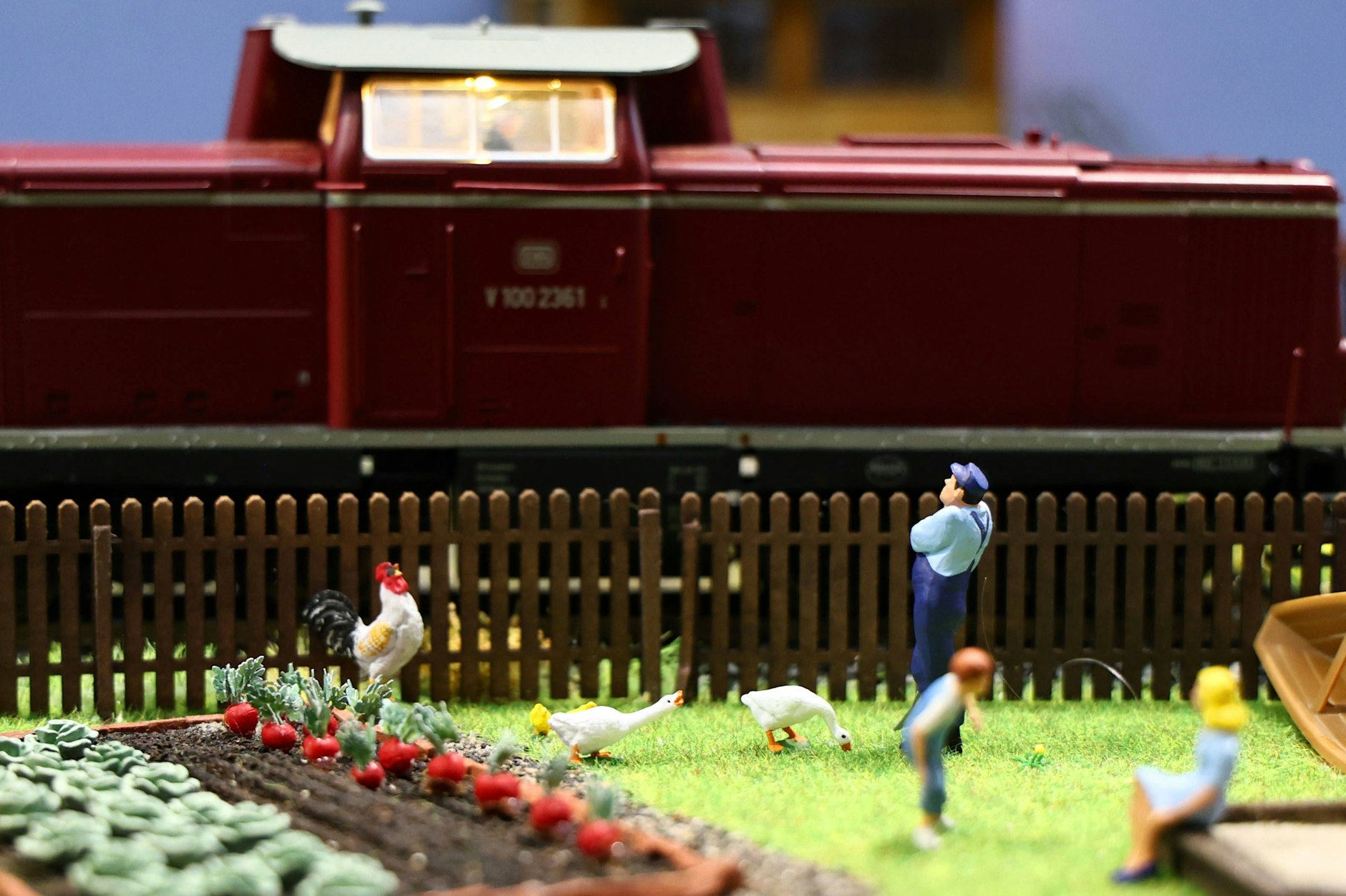 Pünktlich und sauber. Die Eisenbahn fährt an einem Garten vorbei, in dem eine Familie Gemüse anbaut. Alles fast so schön wie früher in Wirklichkeit.