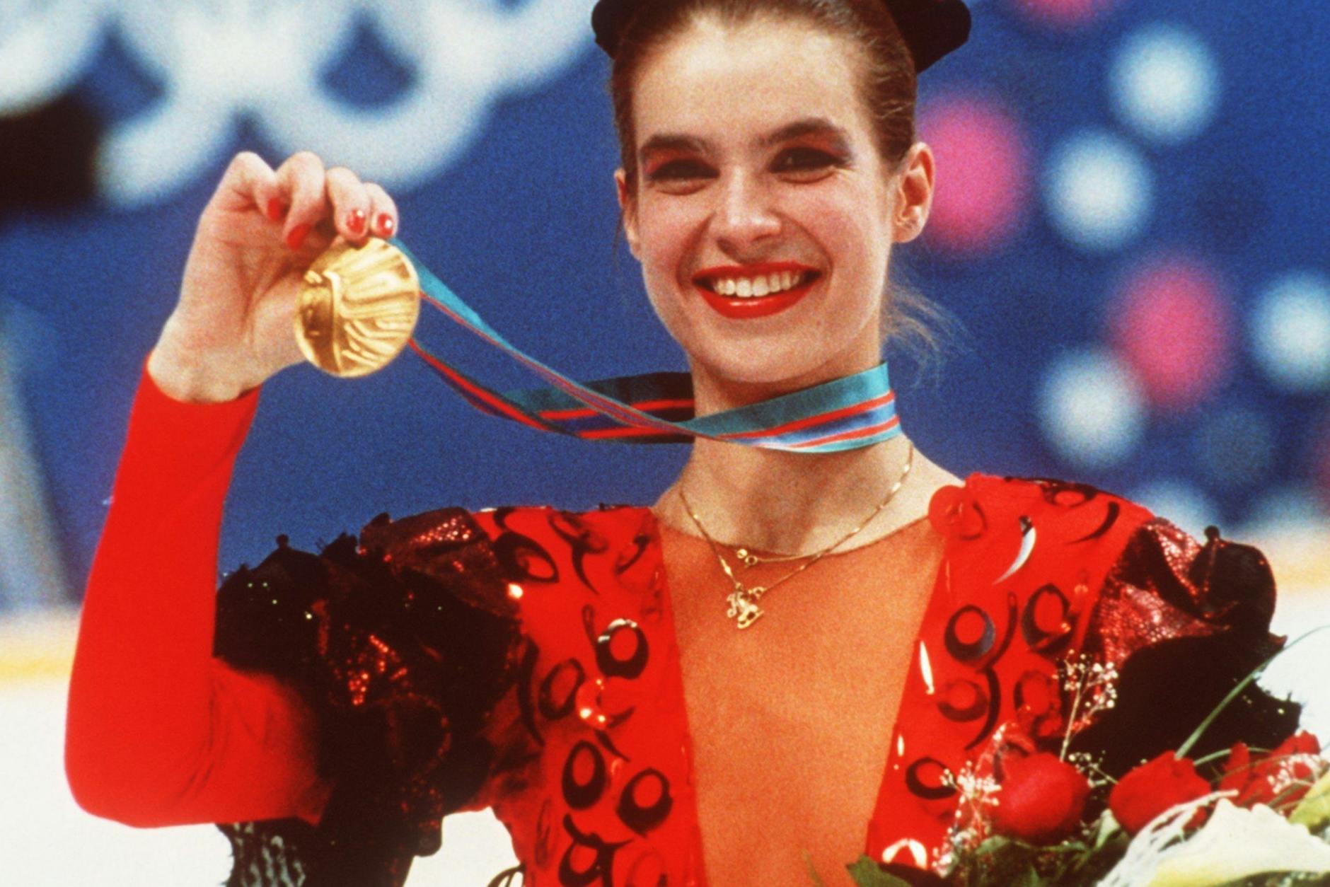 Mit strahlendem Lächeln präsentiert Katarina Witt bei der Siegerehrung am 27.2.1988 bei den Olympischen Winterspielen in Calgary ihre gewonnene Goldmedaille.