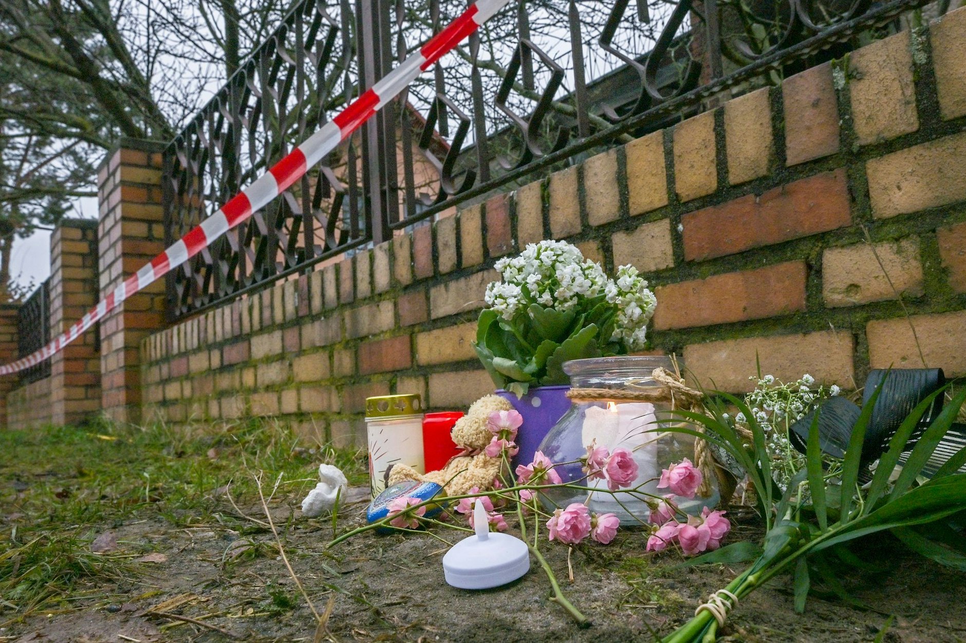 Kerzen und Blumen vor dem ausgebrannten Haus in Mahlsdorf. Hier verlor David (7) sein Leben.