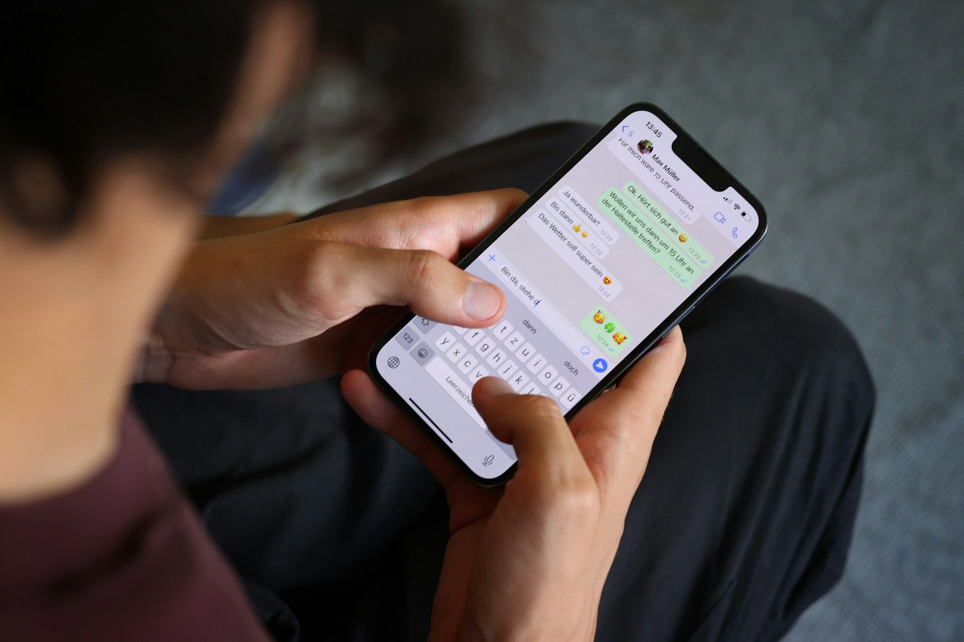 Ein Mann tippt auf einem Smartphone eine WhatsApp Nachricht.