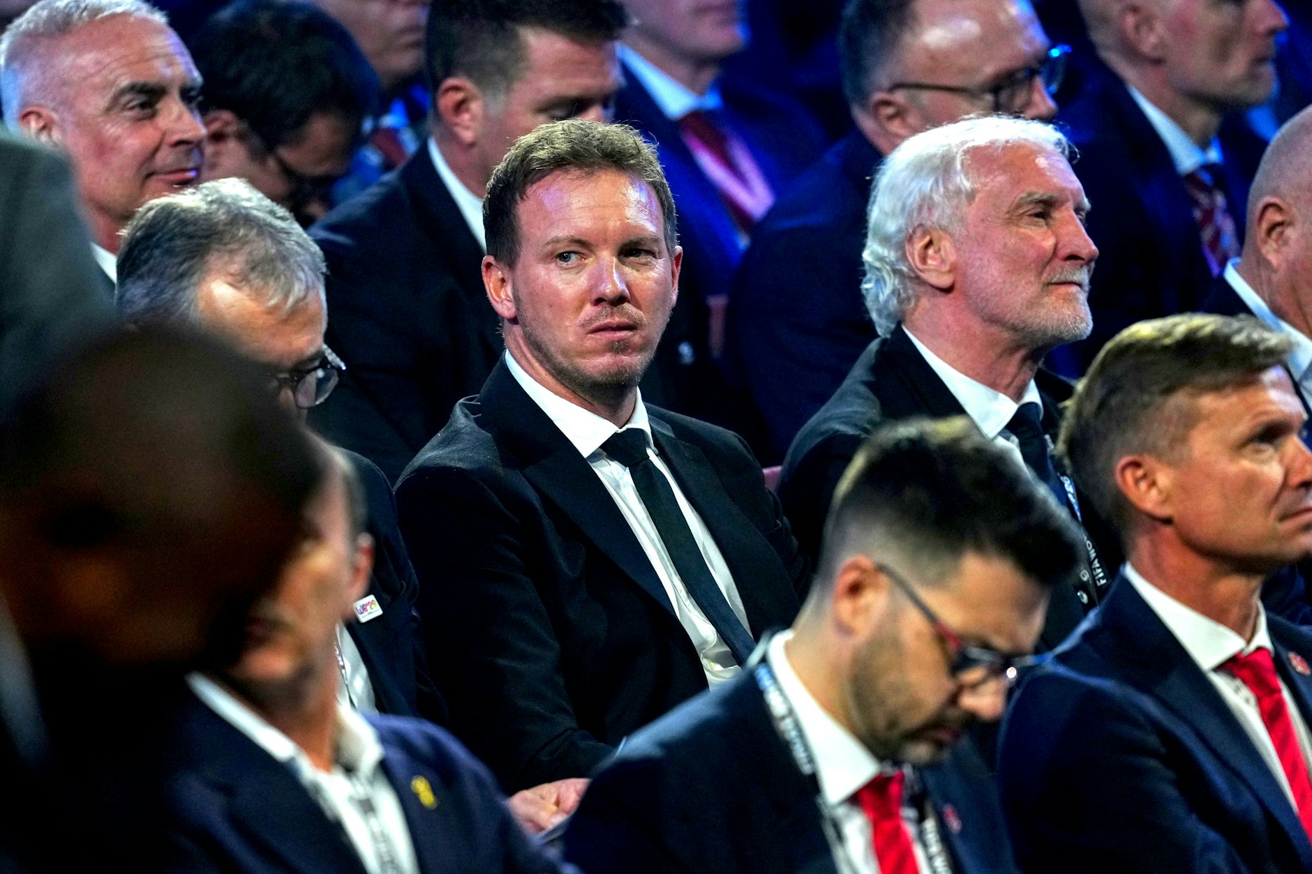 Bundestrainer Julian Nagelsmann (M.) verfolgt mit Sportdirektor Rudi Völler die Auslosung in Washington. 