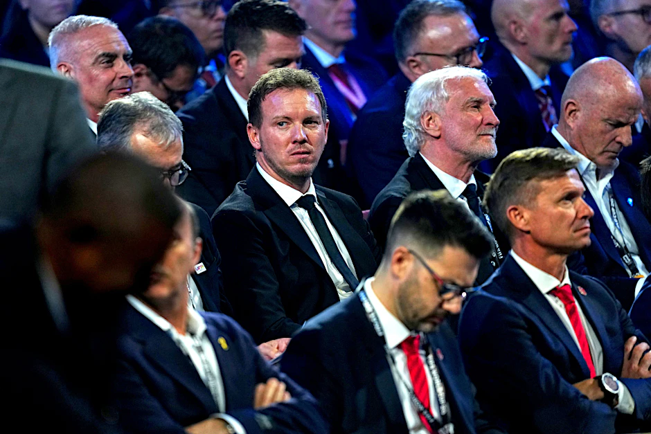 Bundestrainer Julian Nagelsmann (M.) verfolgt mit Sportdirektor Rudi Völler die Auslosung in Washington. 