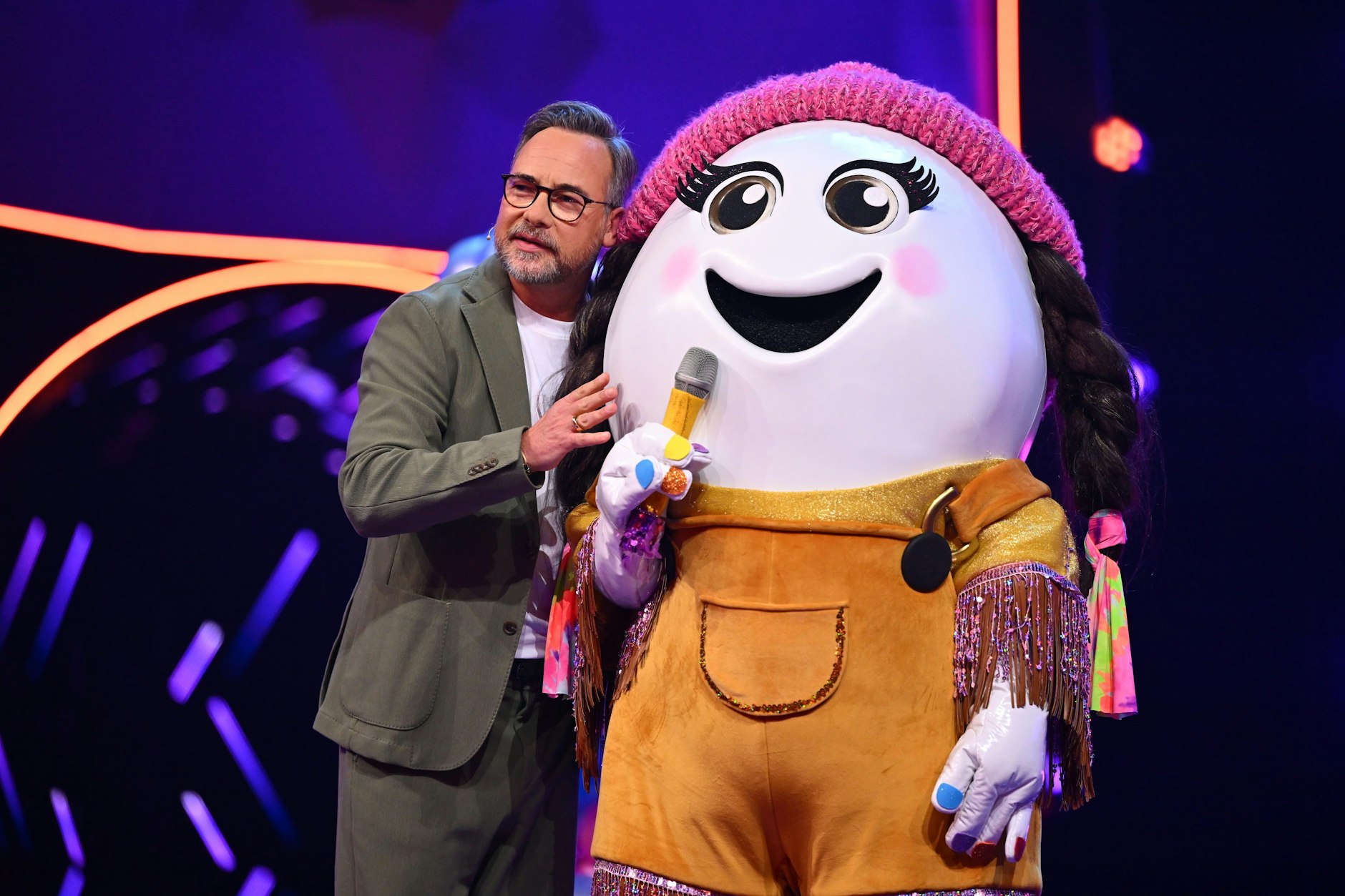 Das Ei Eggi auf der Bühne von „Masked Singer“, zusammen mit Moderator Matthias Opdenhövel. Er weiß genau, wer sich unter der Maske versteckt.