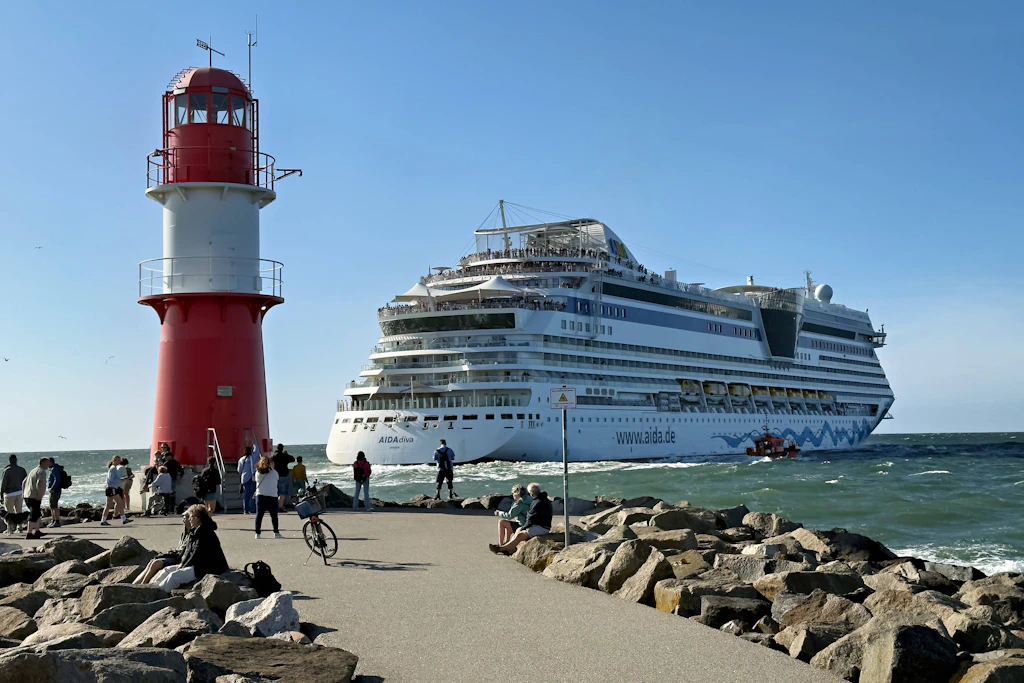 Die Aida Diva beim Auslaufen aus dem Hafen von Warnemünde, im Vordergrund der Leuchtturm.
