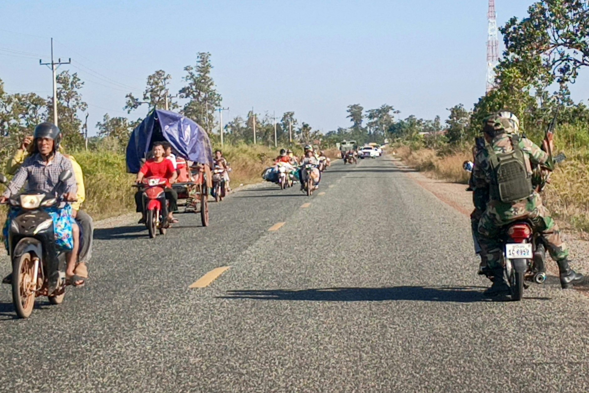 Kambodschanische Soldaten (r.) fahren auf einem Motorrad, während Einwohner nach Zusammenstößen entlang der kambodschanisch-thailändischen Grenze in der Provinz Preah Vihear am 8. Dezember das Gebiet evakuieren.