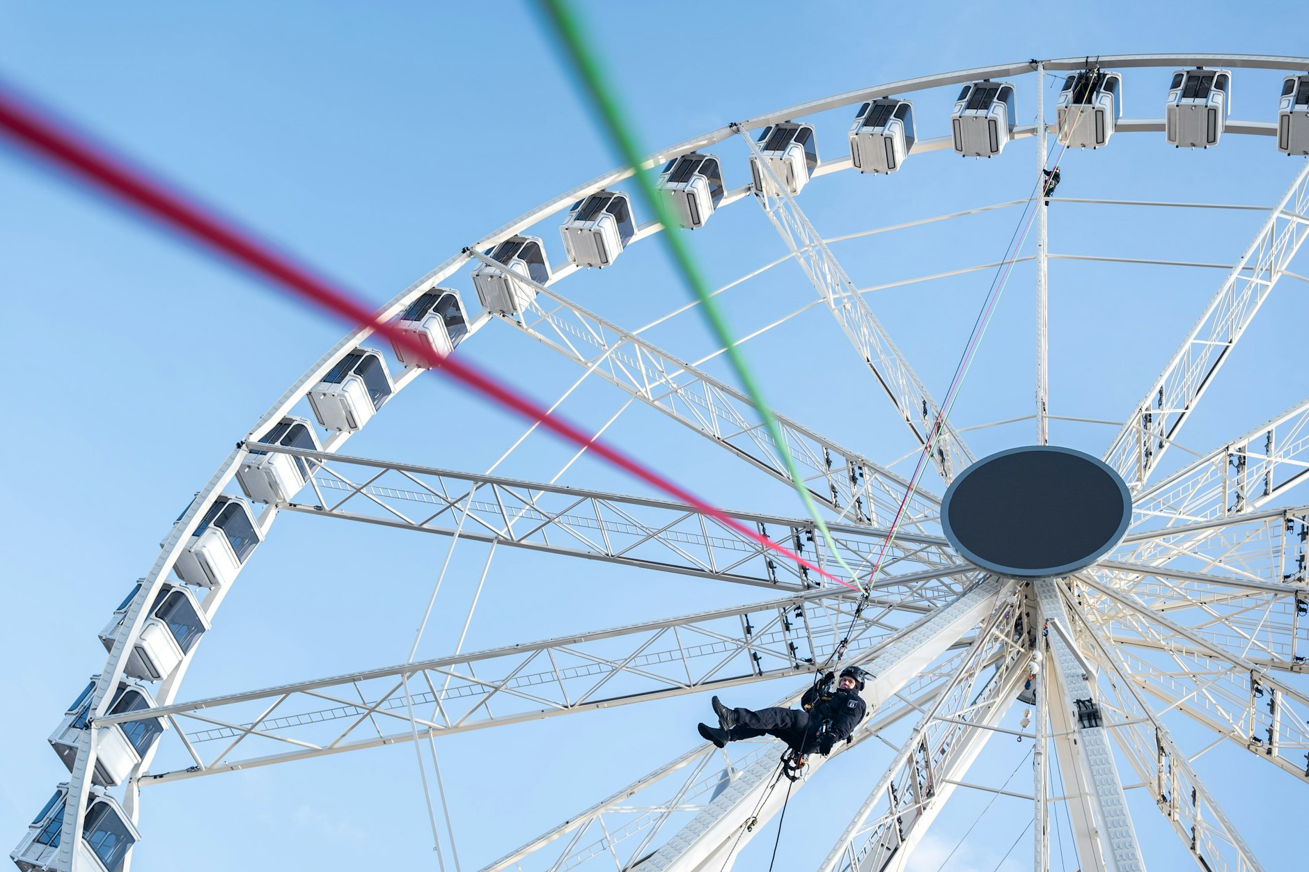 Ein Polizist der Höhenrettung seilt sich aus der obersten Gondel in Richtung Boden ab.