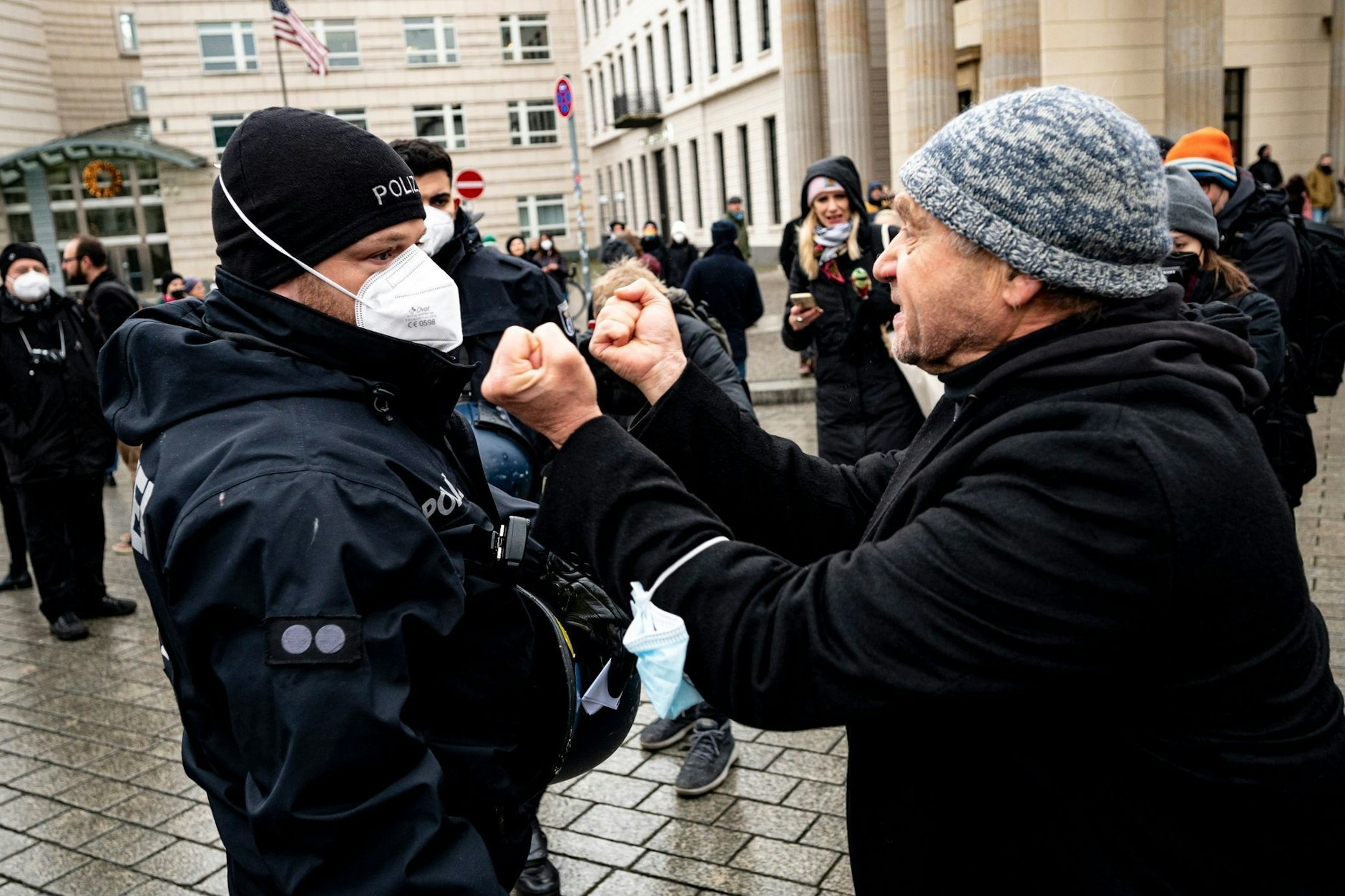 Ein Teilnehmer einer Demonstration gegen Corona-Maßnahmen diskutiert mit einem Polizisten.