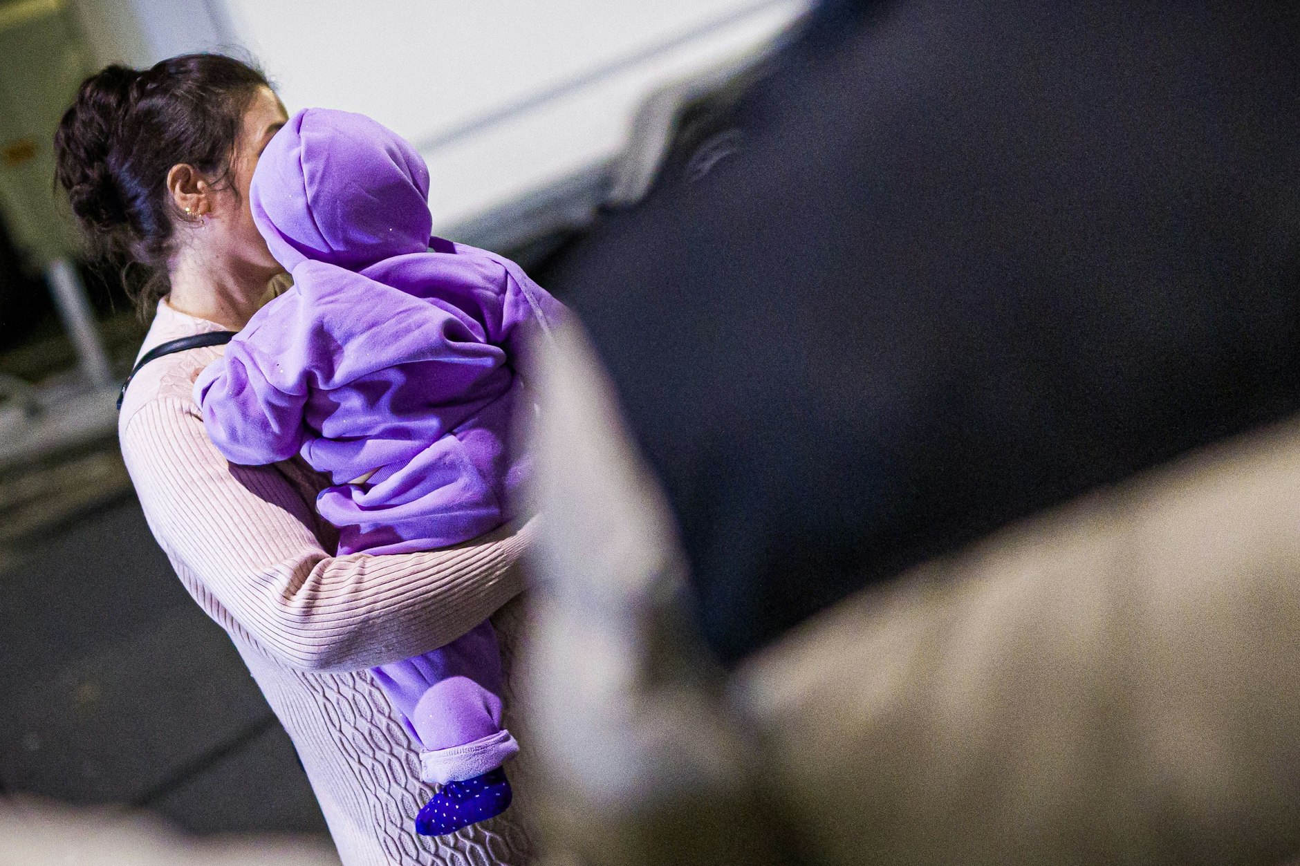 Eine Mutter aus Afghanistan, die zuvor mit ihrem Kind in einem Flugzeug auf dem Flughafen Hannover-Langenhagen gelandet ist, steht vor dem Flughafen.