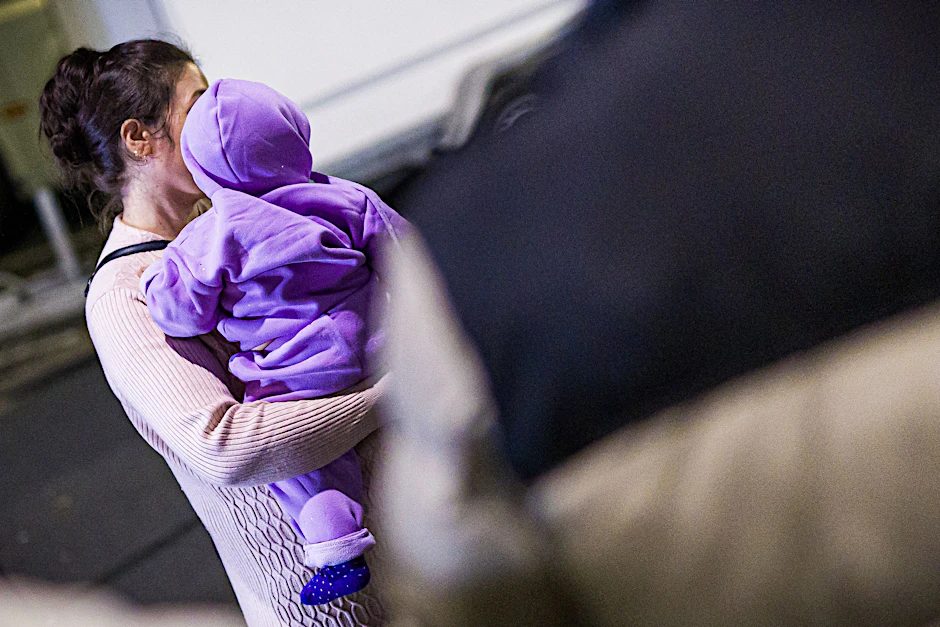 Eine Mutter aus Afghanistan, die zuvor mit ihrem Kind in einem Flugzeug auf dem Flughafen Hannover-Langenhagen gelandet ist, steht vor dem Flughafen.