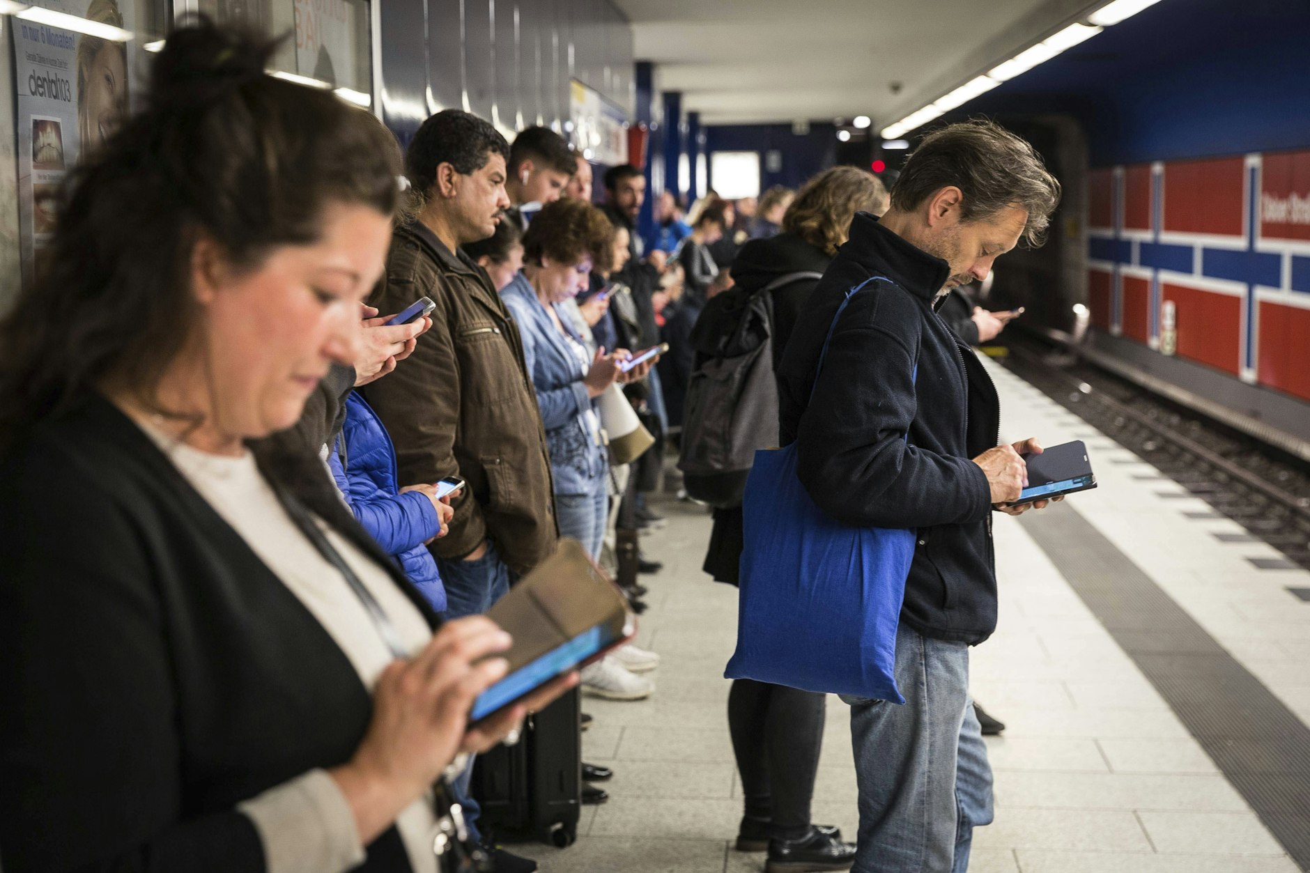 Fahrgäste daddeln auf ihren Smartphones, während sie auf dem U-Bahnhof Osloer Straße auf den Zug warten. Doch nicht immer funktioniert das Gratis-Internet der BVG.