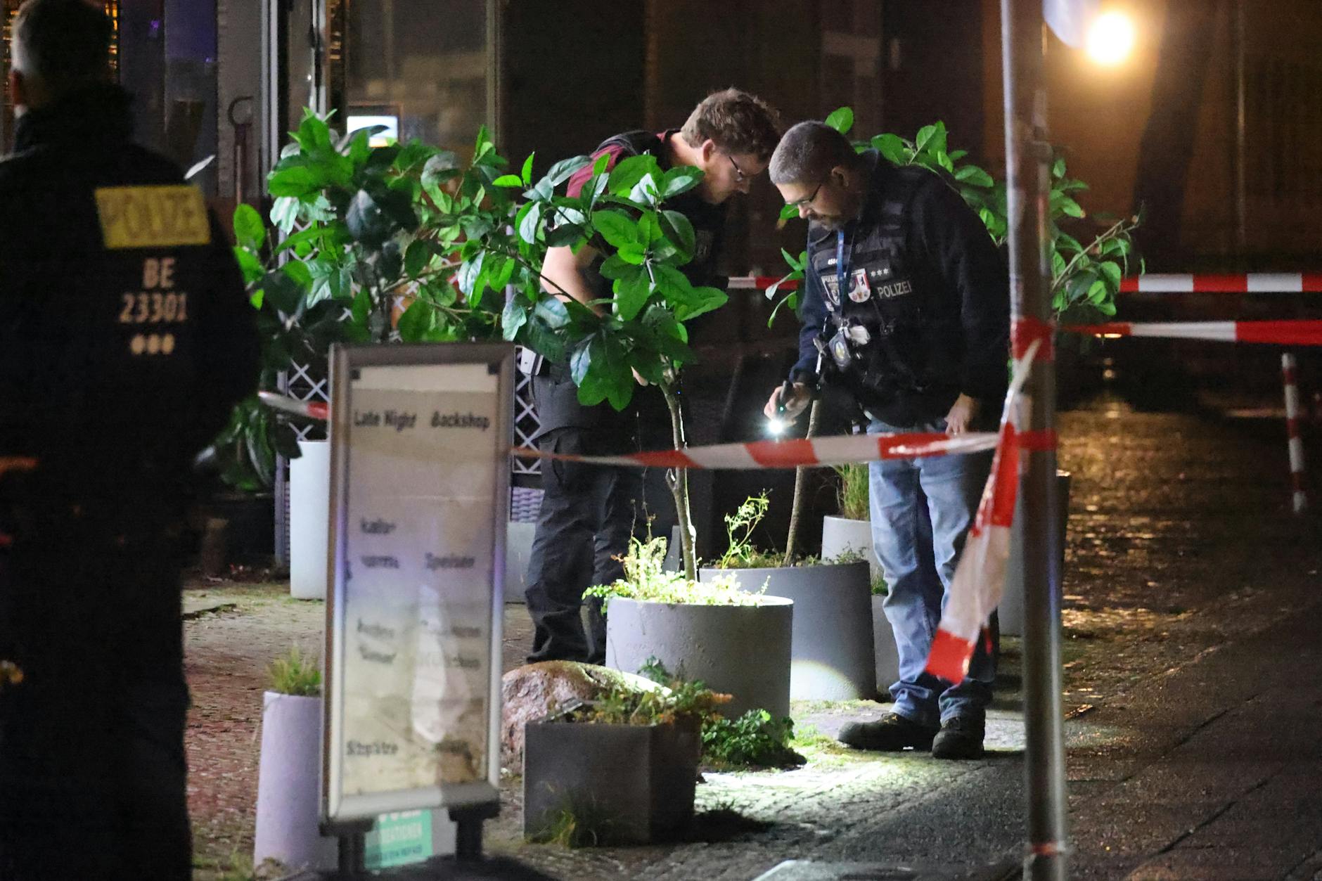 Zwei Beamte suchen nach Spuren der Schießerei.
