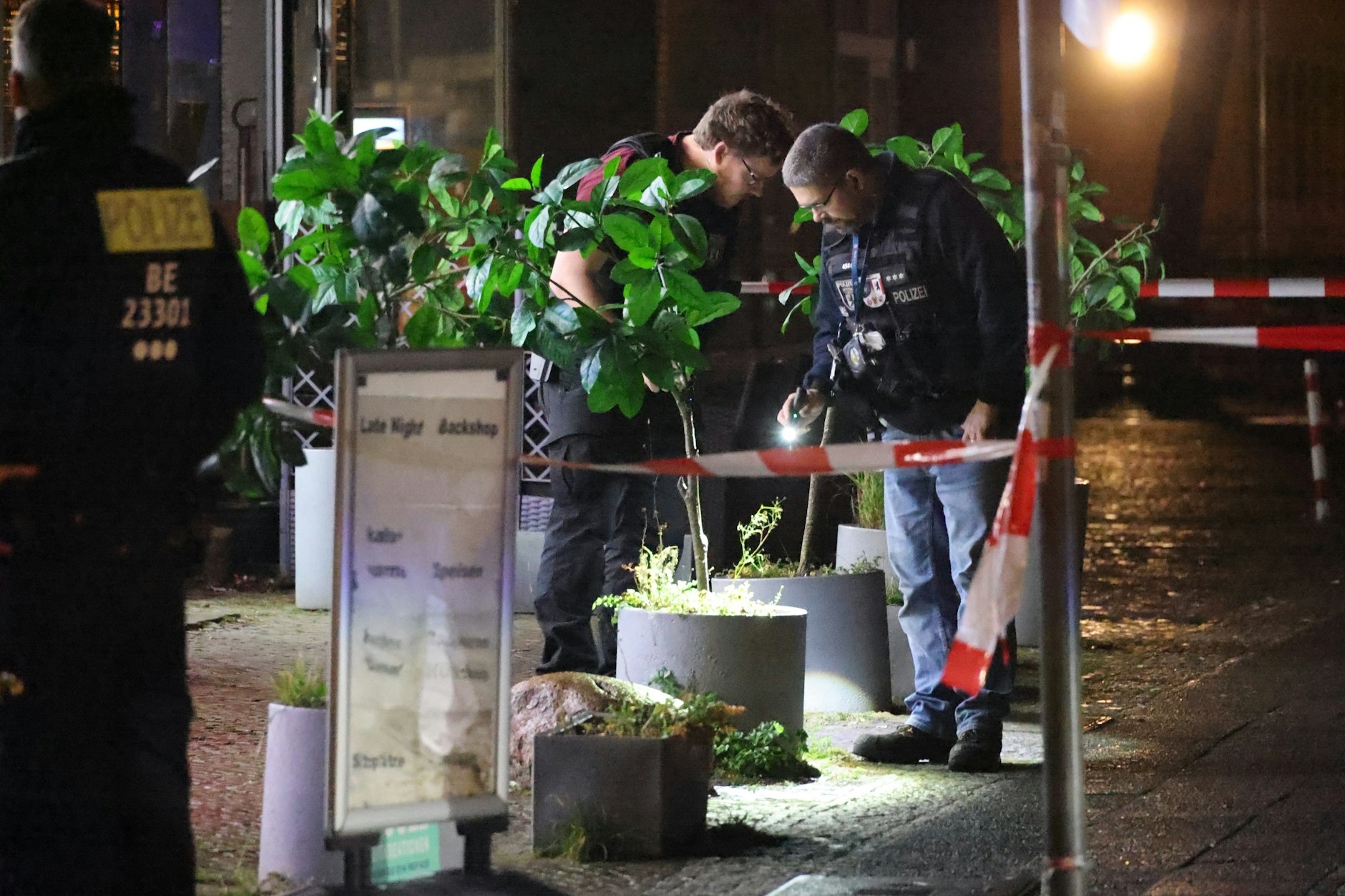 Zwei Beamte suchen nach Spuren der Schießerei.