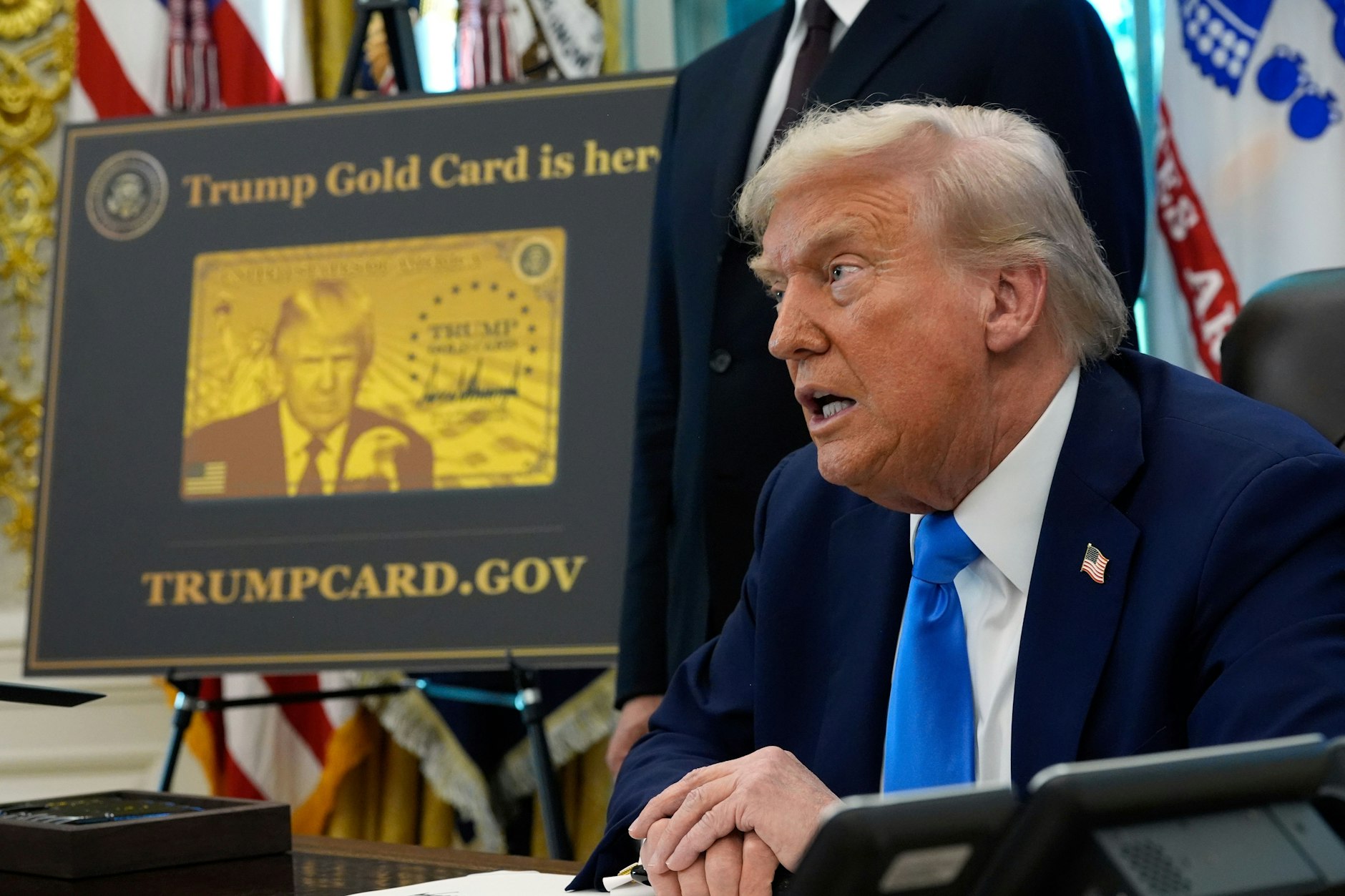 Washington: Ein Poster mit der Trump Gold Card ist zu sehen, während US-Präsident Donald Trump im Oval Office des Weißen Hauses Anordnungen unterzeichnet.