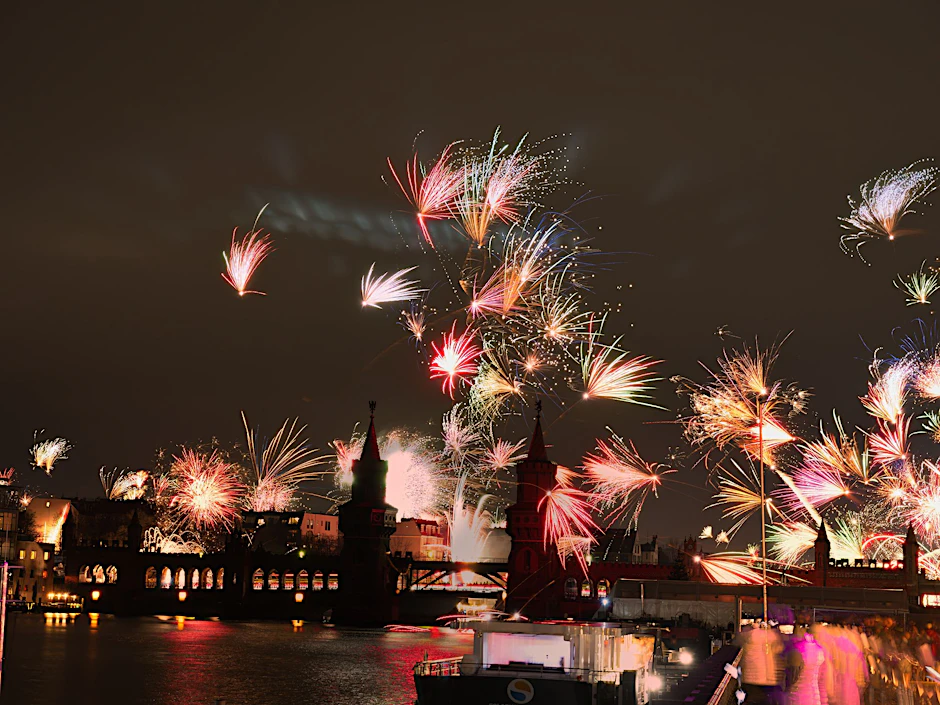 Feuerwerkskörper gehen an Silvester hinter der Oberbaumbrücke in den Nachthimmel hoch.
