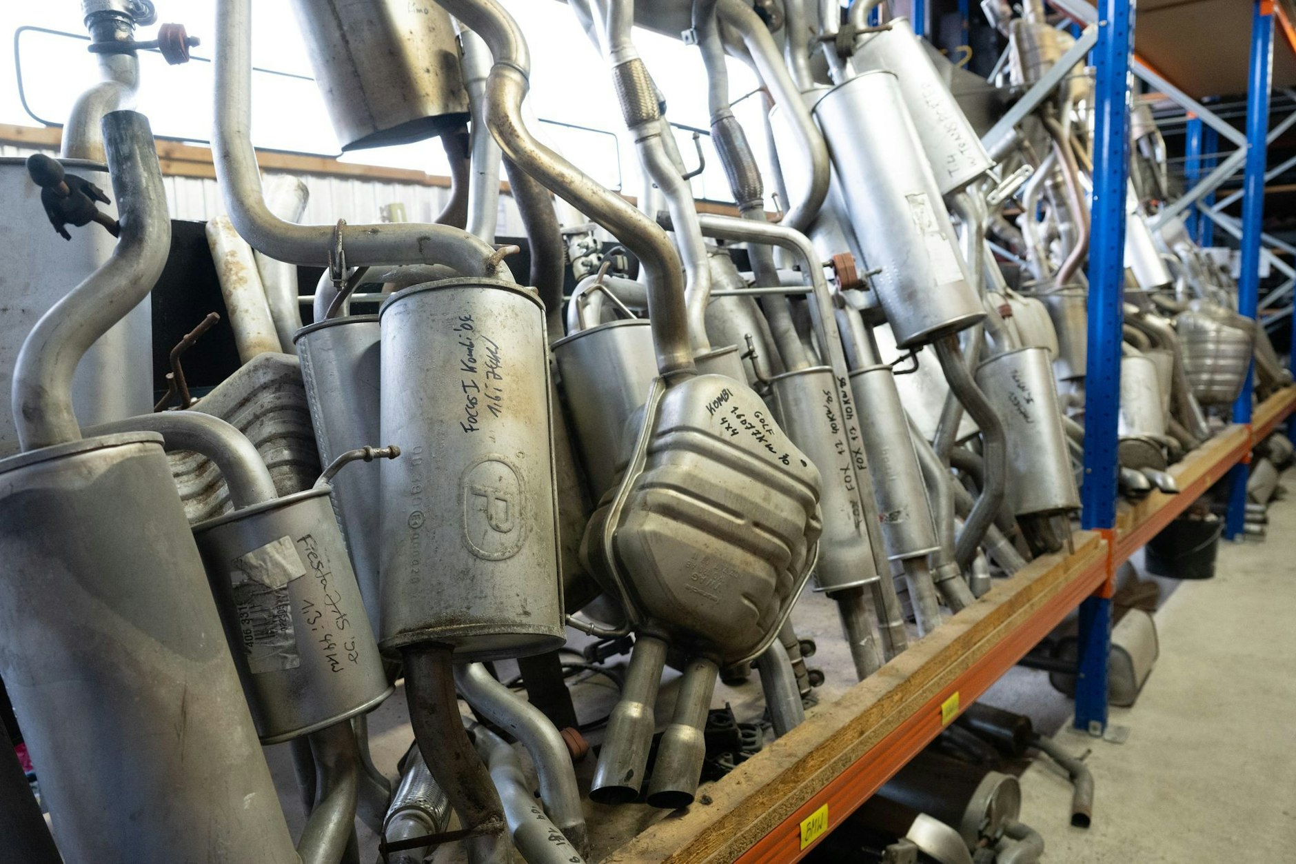 Abgasrohre verschiedener Fahrzeuge im Lager einer Autoverwertung. Vor allem viele kleine Mittelständler müssen dieser Tage dichtmachen.