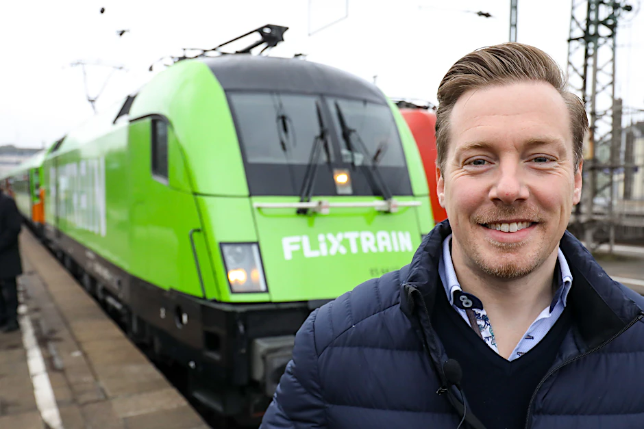 André Schwämmlein, Unternehmer und Gründer von Flixbus, steht  auf dem Bahnhof Altona vor dem Flixtrain. 