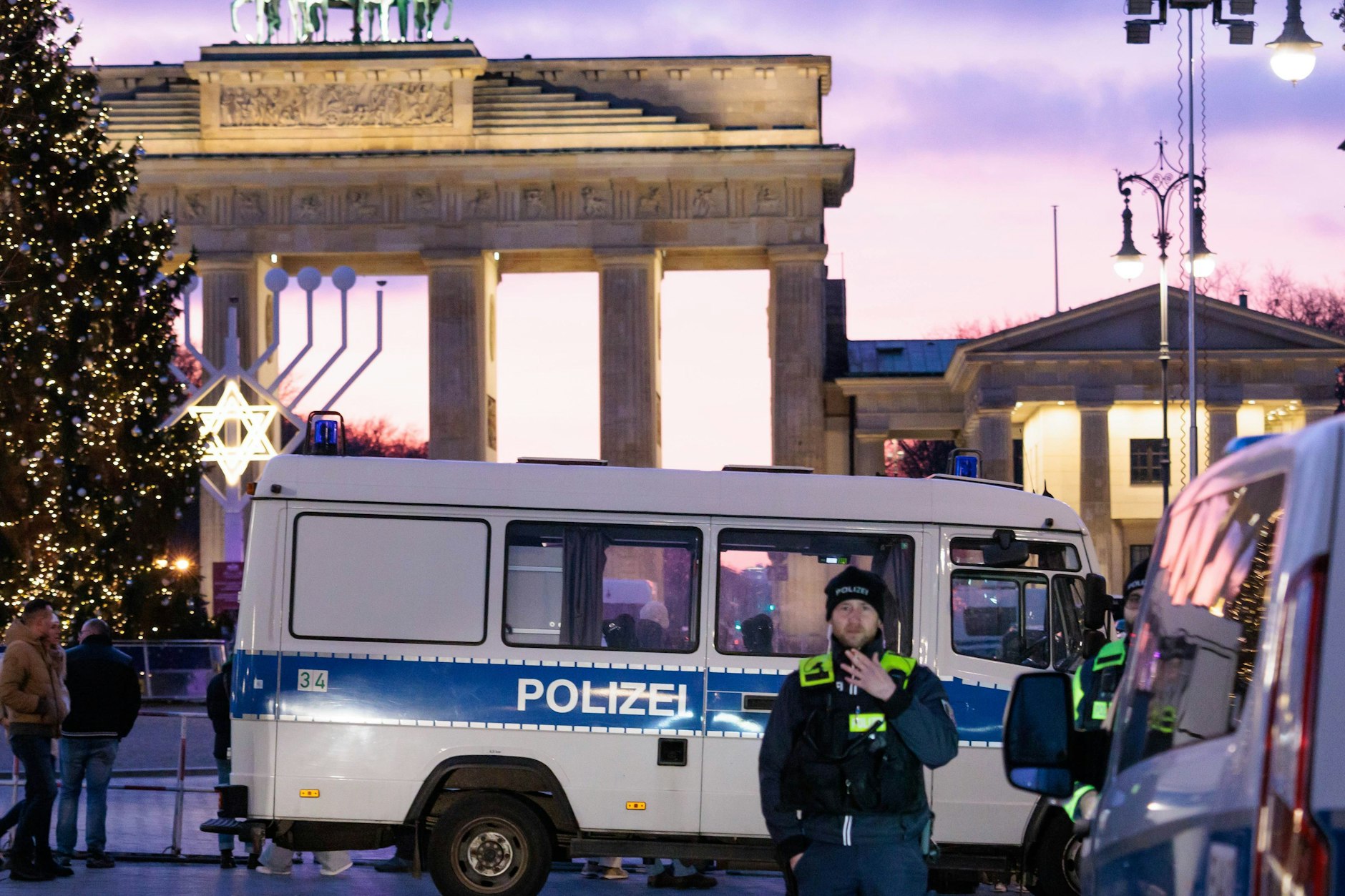 Polizisten stehen am Sonntag hinter Absperrgittern in der Nähe des Brandenburger Tors.