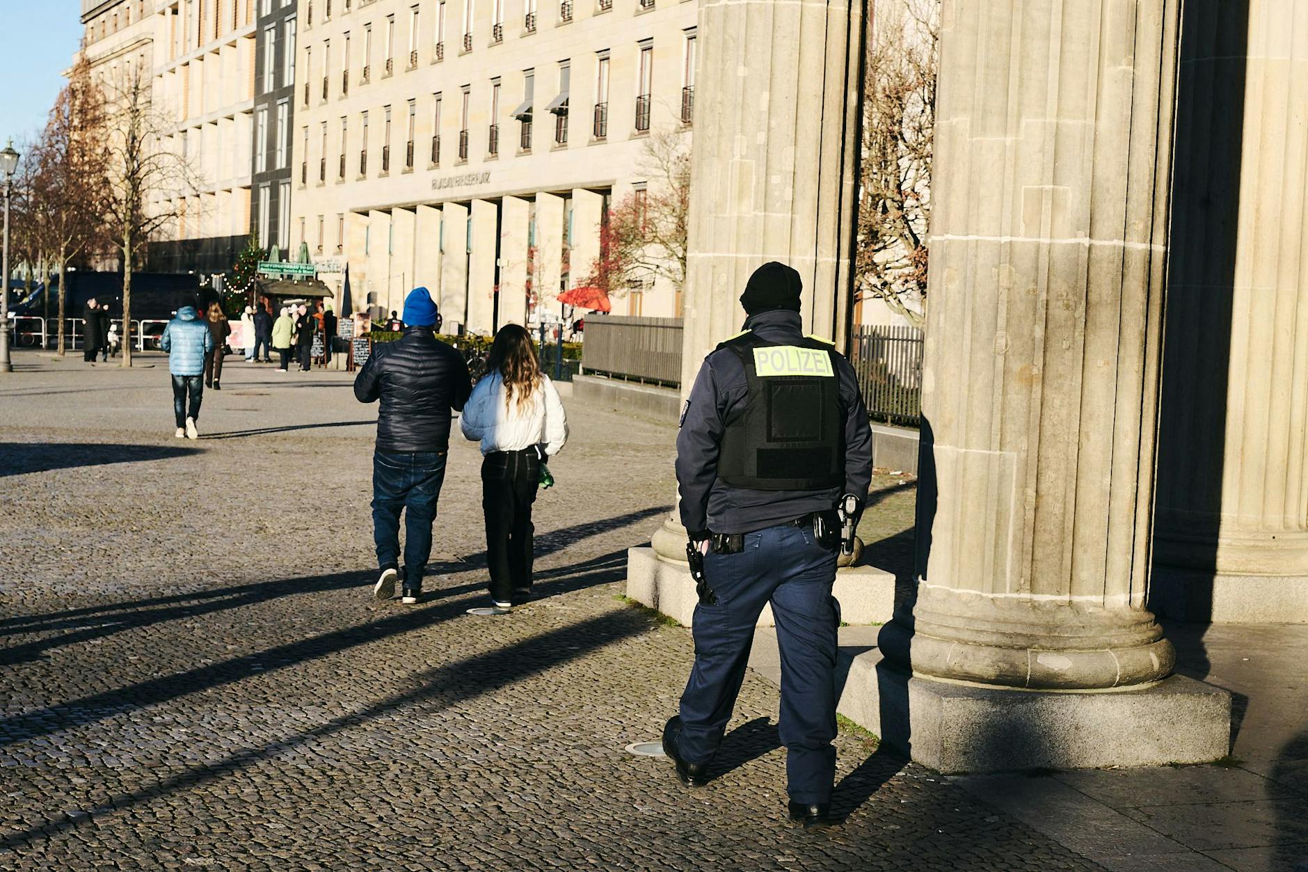 Noch ist alles ruhig: Ein Polizist patrouilliert am Brandenburger Tor entlang.