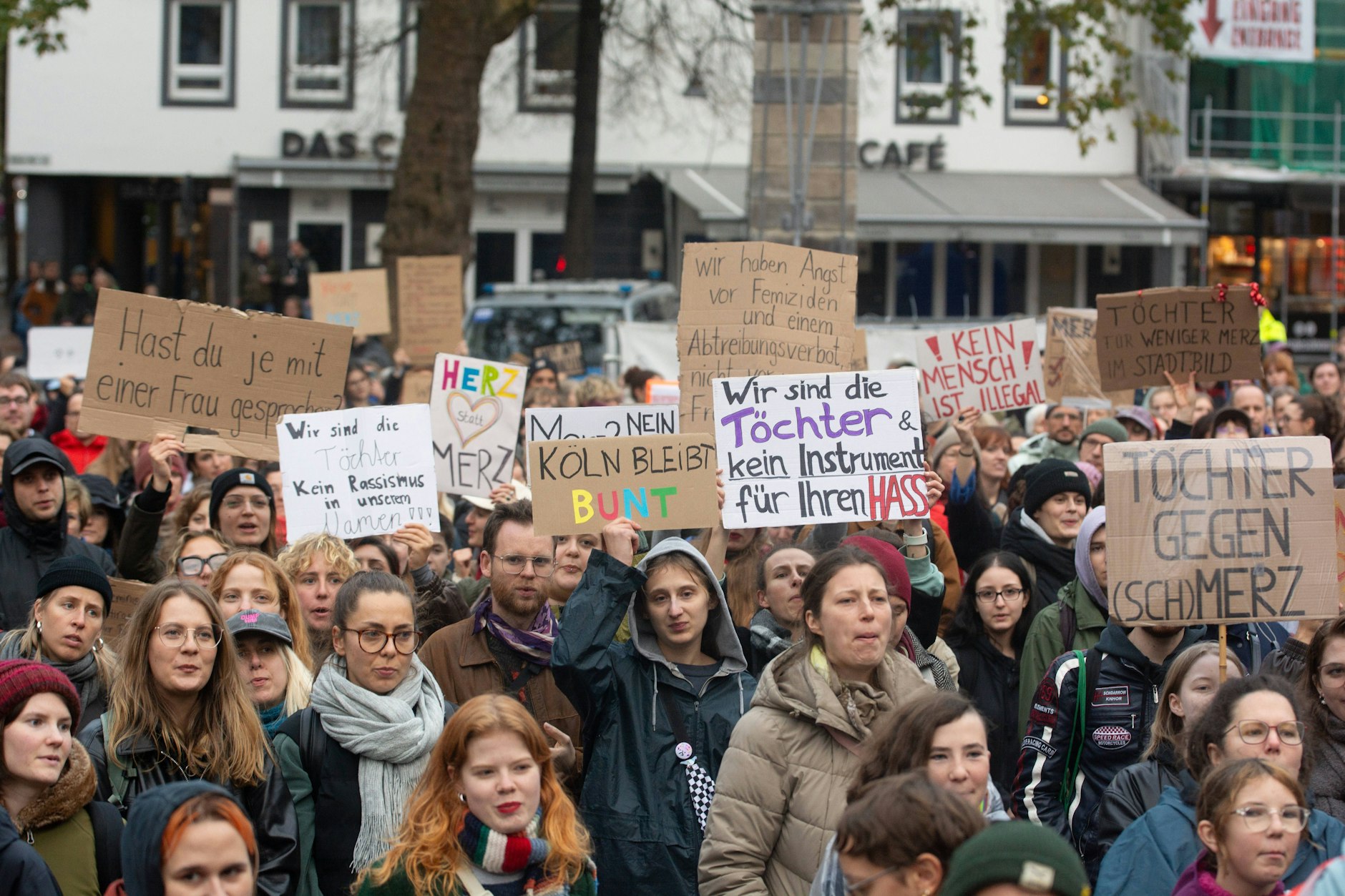Teilnehmer einer linken Demonstration mit selbstgestalteten Protestschildern in Köln