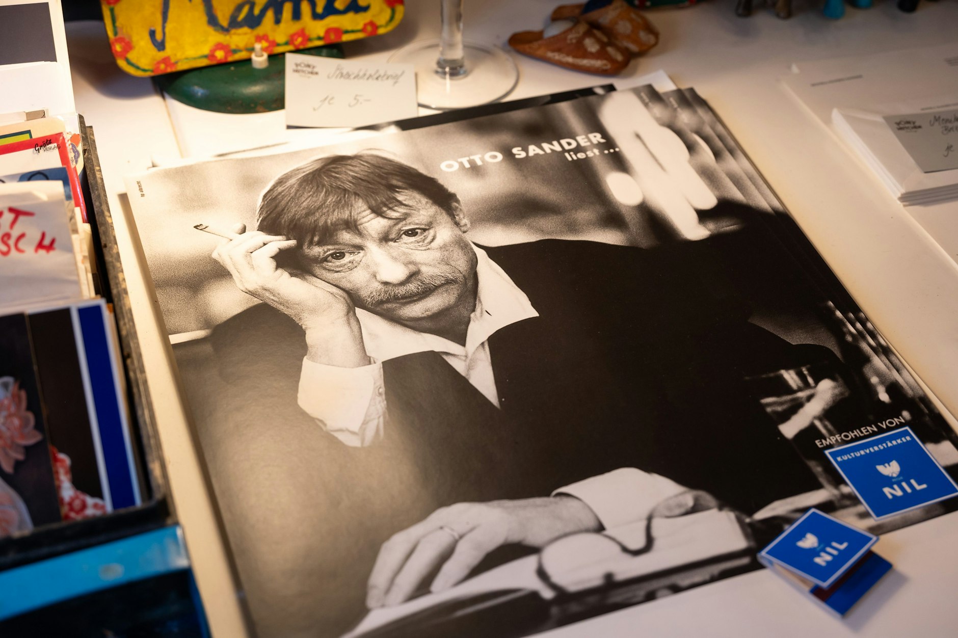 Auf einem Tisch liegen viele Poster von Otto Sander. Diese sind für 5 Euro zu haben.