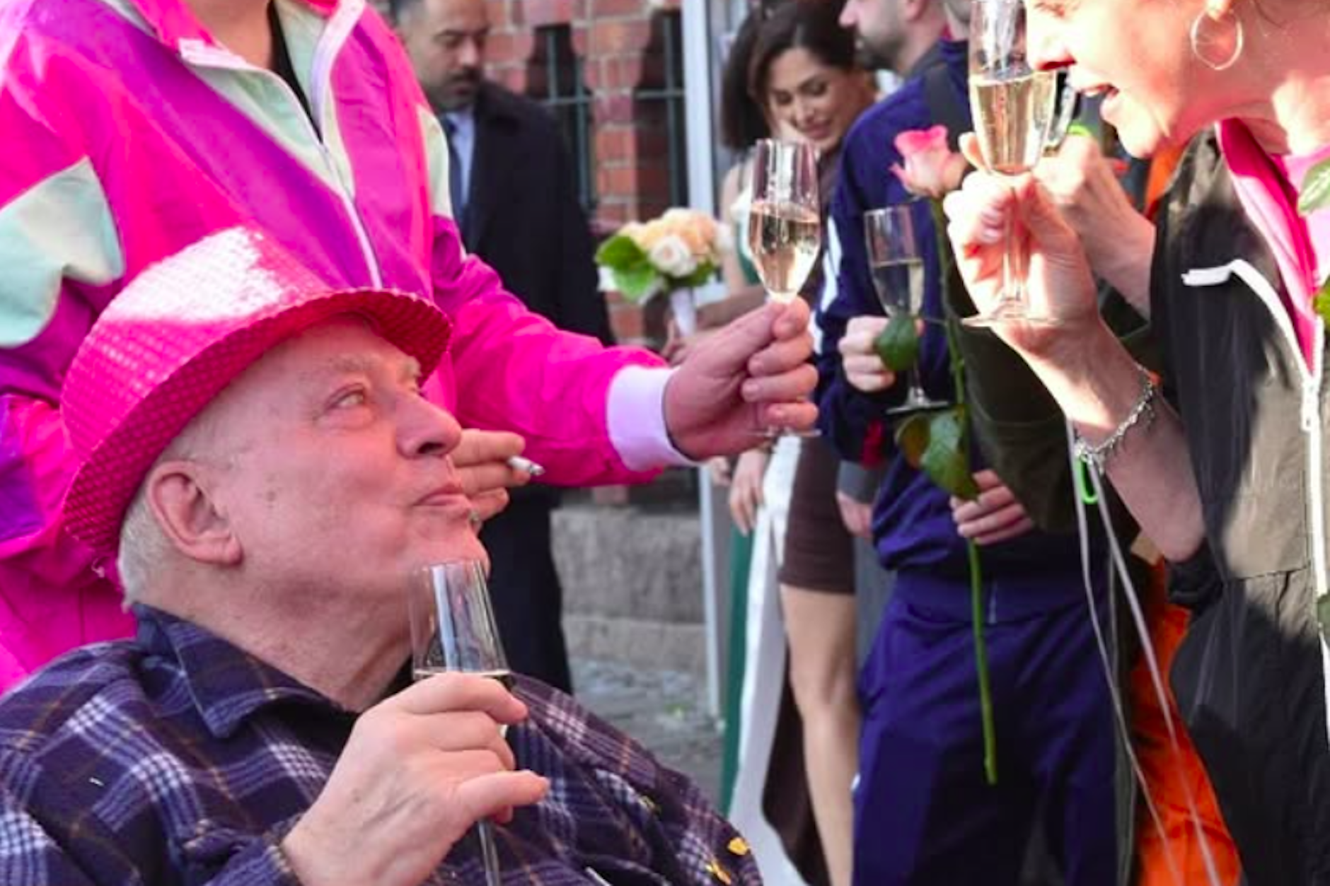 Freudiger Moment nach der Trauung. Rosa von Praunheim stößt mit Gästen vor dem Rathaus Schmargendorf auf die Hochzeit an.