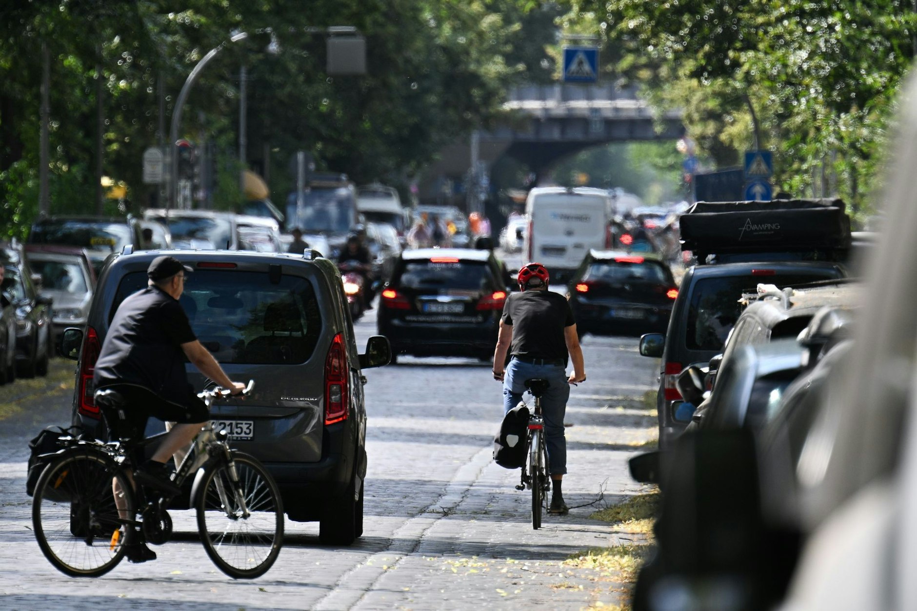 Autos, Fahrradfahrer und Fußgänger auf einer Straße in Kreuzberg