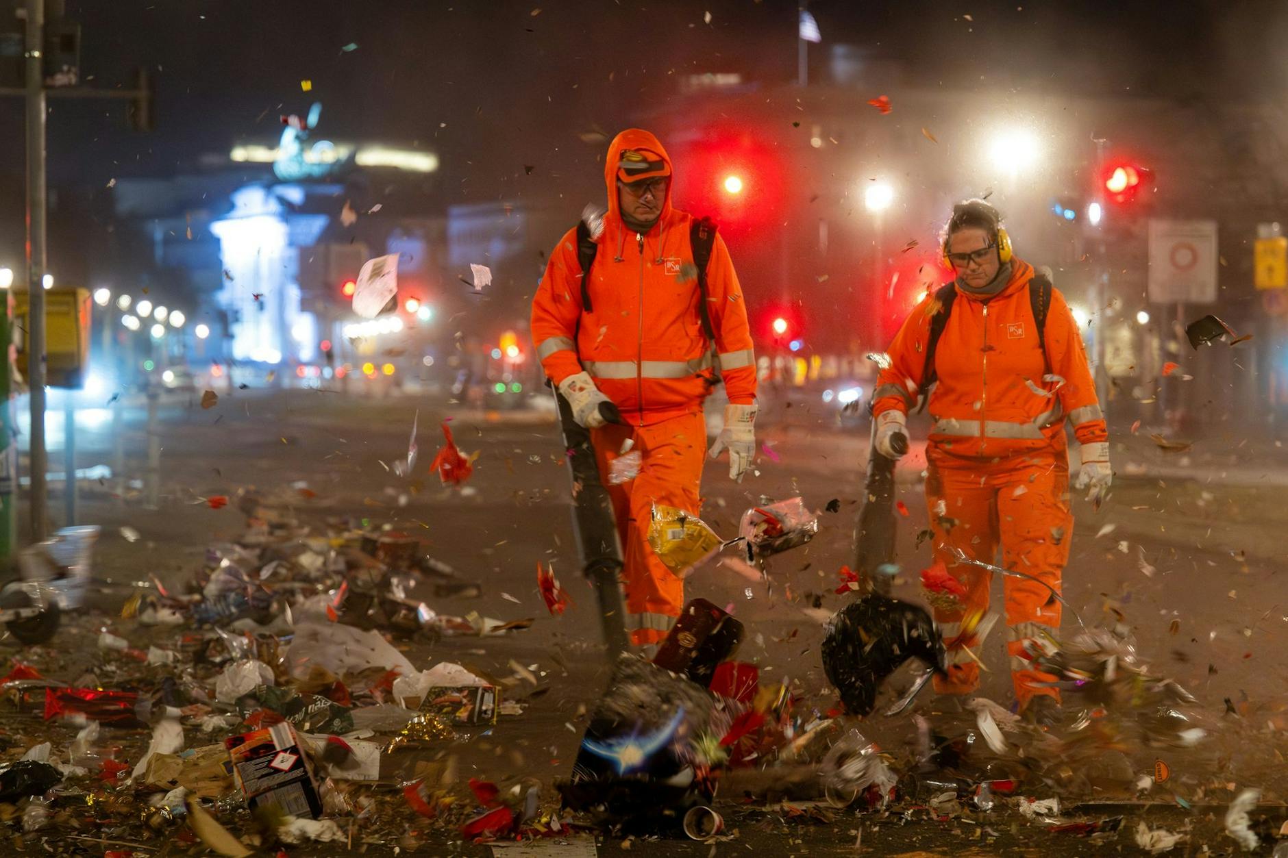 Mitarbeiter der Berliner Stadtreinigung (BSR) blasen mit Laubbläsern den Müll der Silvesternacht weg. Etwa 500 Mitarbeiter sind Neujahr unterwegs.