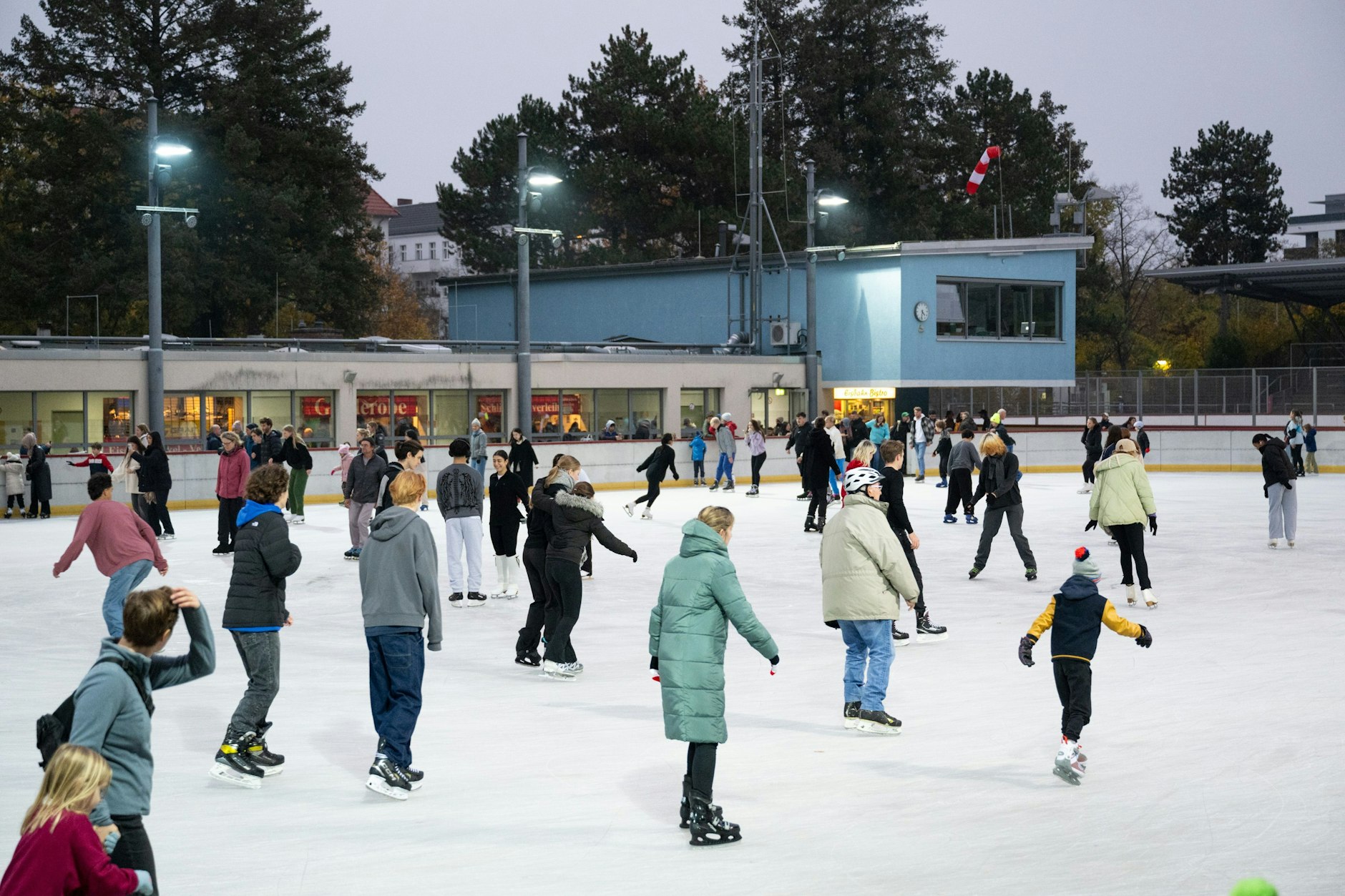 Unter freiem Himmel sind Schlittschuhläufer im Neuköllner Eisstadion unterwegs.