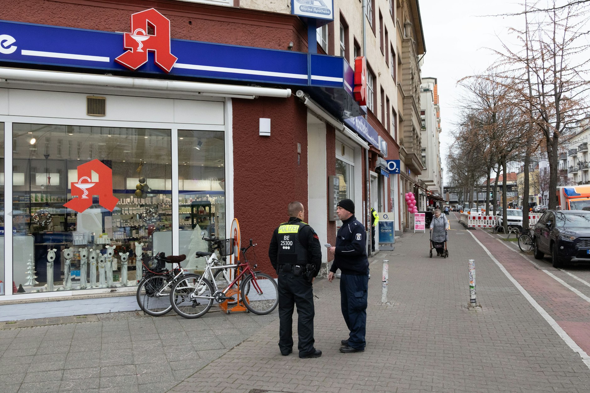 An einer Apotheke in der Kiefholzstraße sicherten Polizisten Spuren und befragten Zeugen nach dem bewaffneten Überfall auf einen Geldboten.