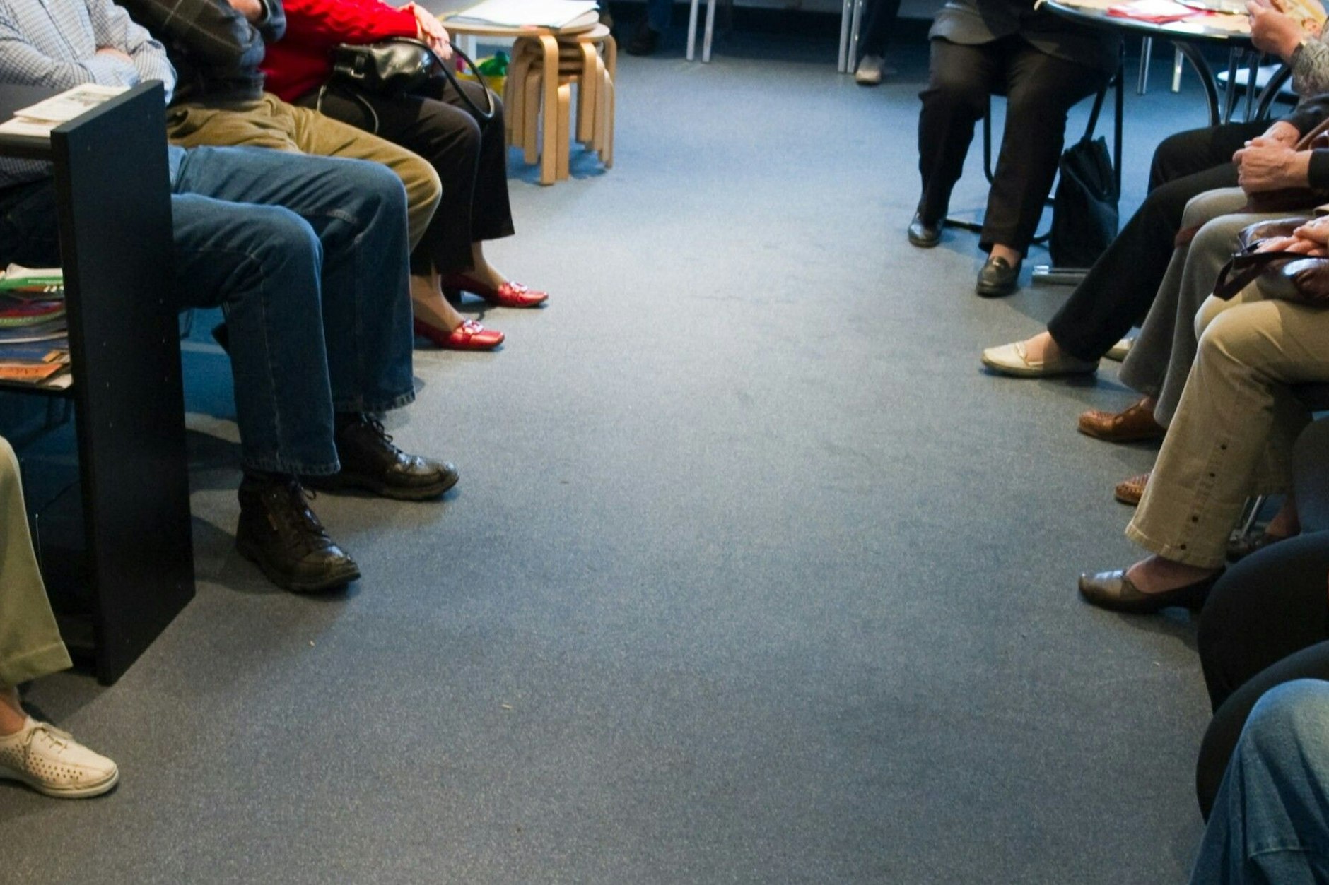 Patienten warten in einem überfüllten Wartezimmer darauf, aufgerufen zu werden.