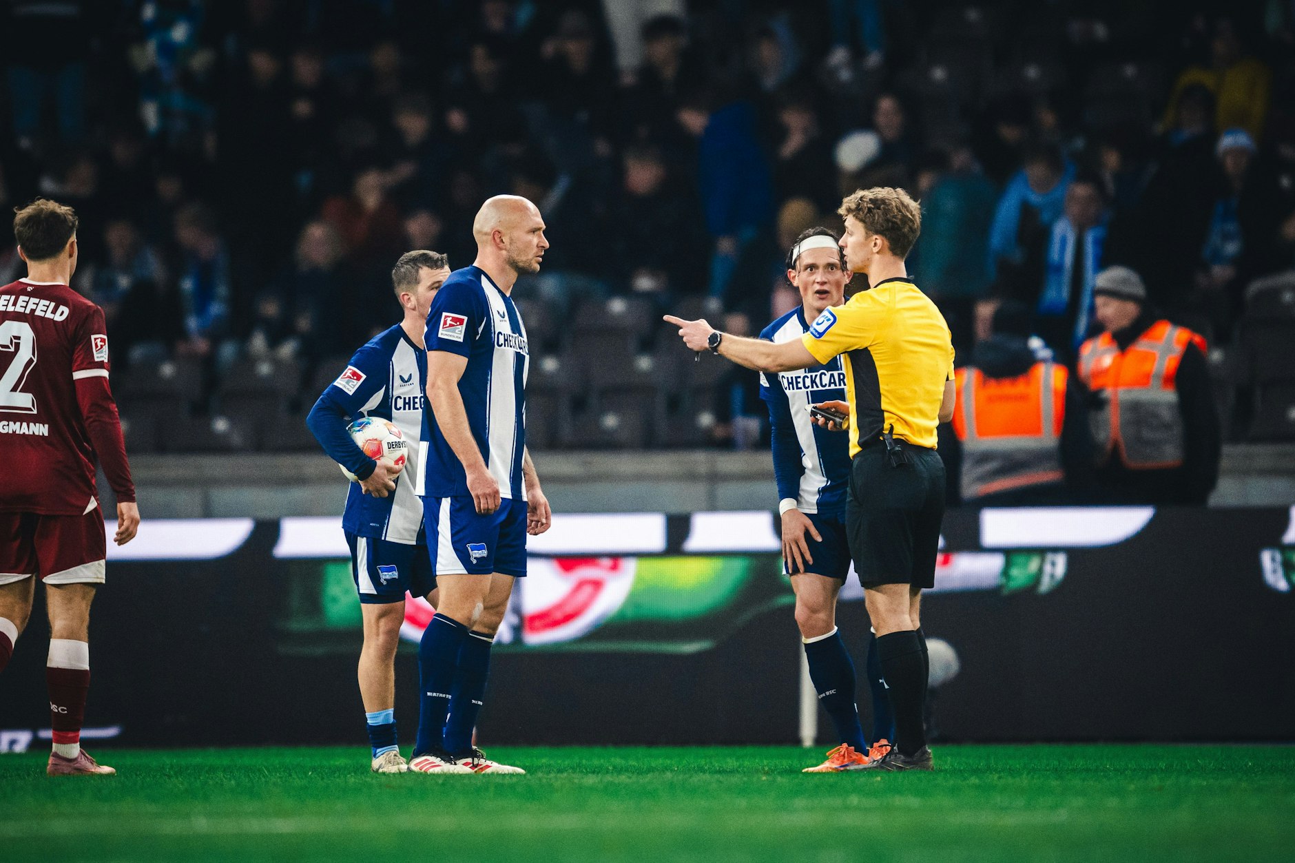 Toni Leistner und Fabian Reese von Hertha BSC diskutieren mit Schiedsrichter Jarno Wienefeld wegen der fragwürdigen Roten Karte für Leistner. 