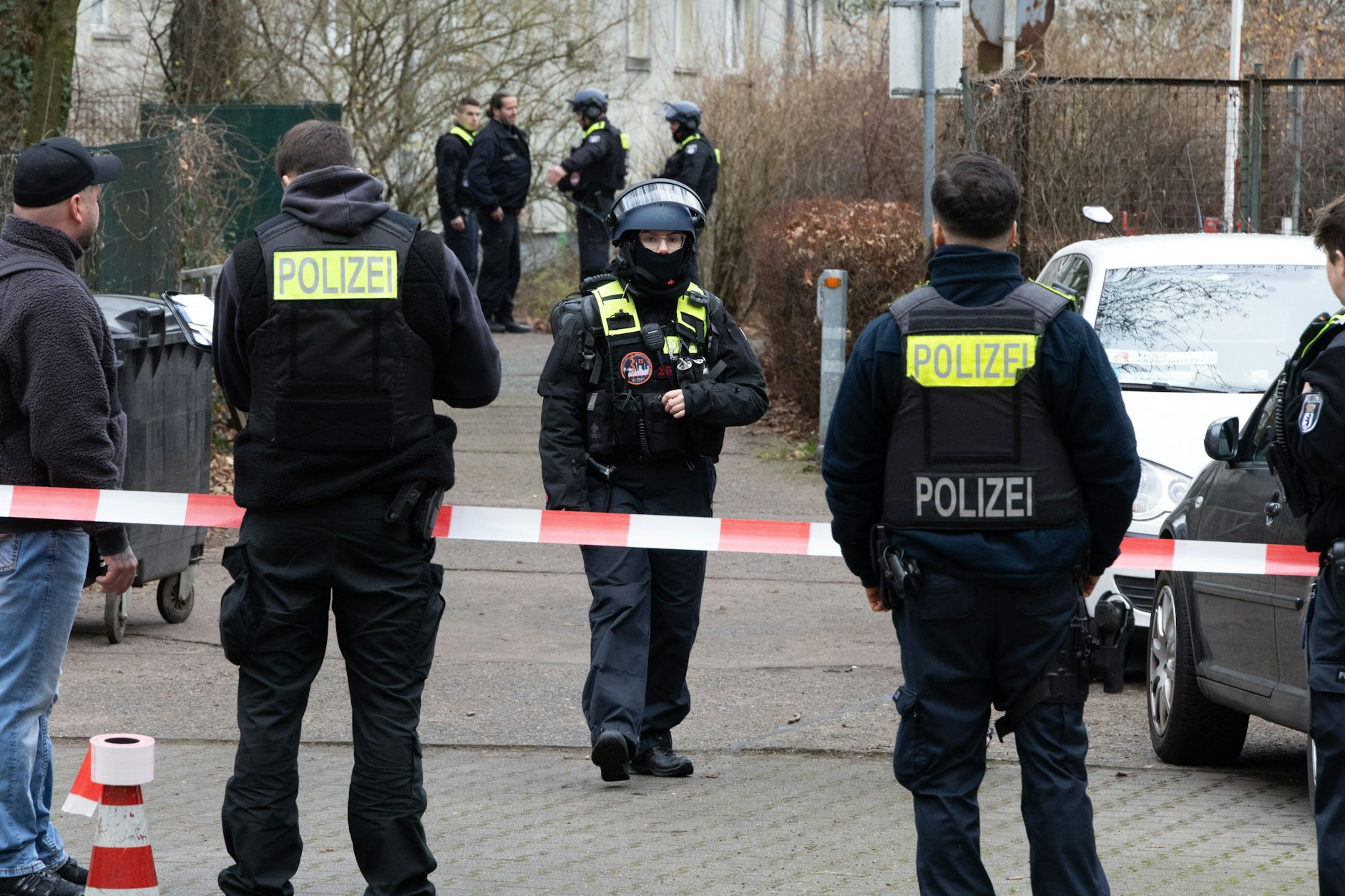 Nach dem bewaffneten Überfall auf einen Geldboten an einer Apotheke sperrten Beamte den Tatort ab und suchten nach den flüchtigen Tätern.