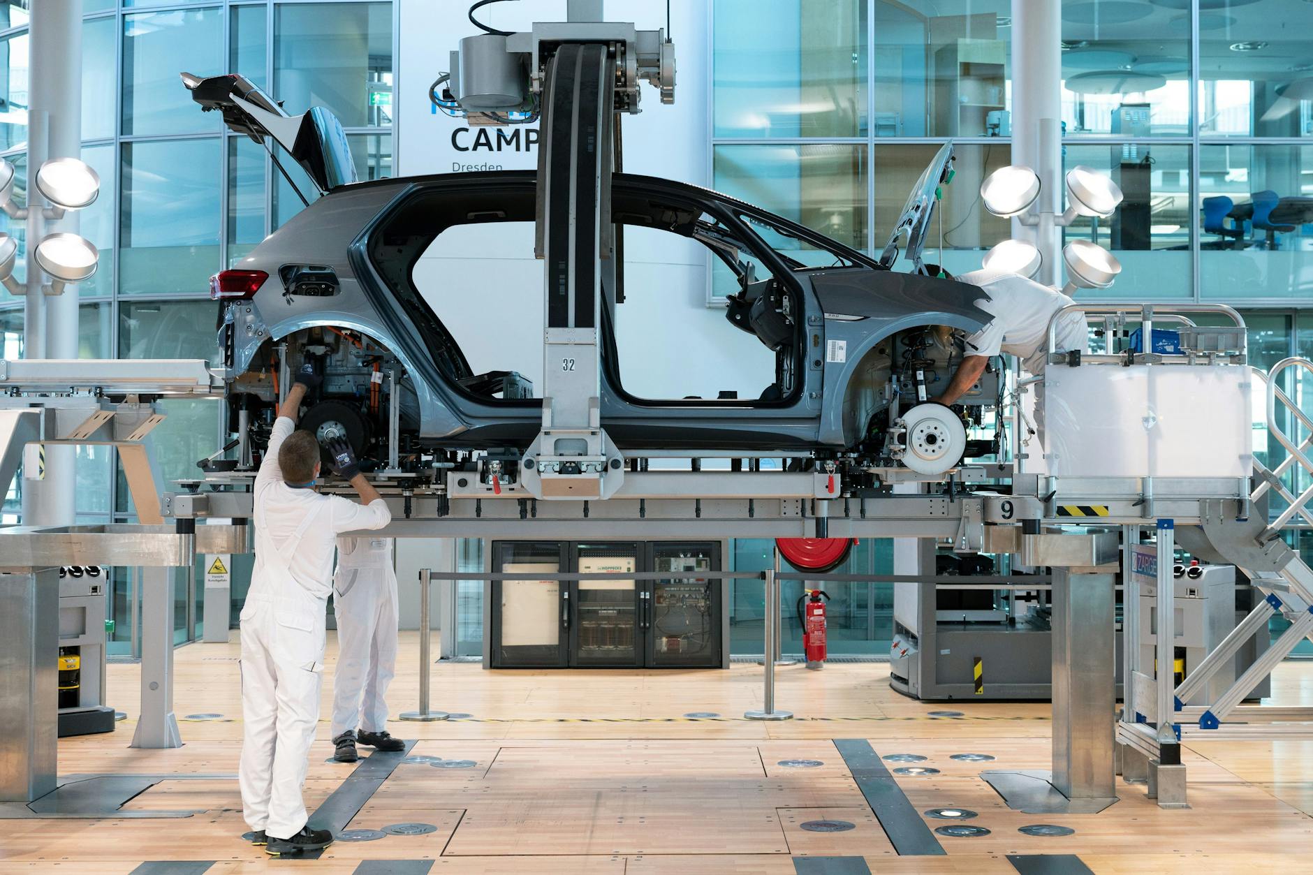 Sachsen, Dresden: VW-Mitarbeiter montieren im Juni 2021 in der Gläsernen Manufaktur die Karosserie und den Antriebsstrang eines VW ID.3. Inzwischen ist die Produktion eingestellt worden. Symbolbild.